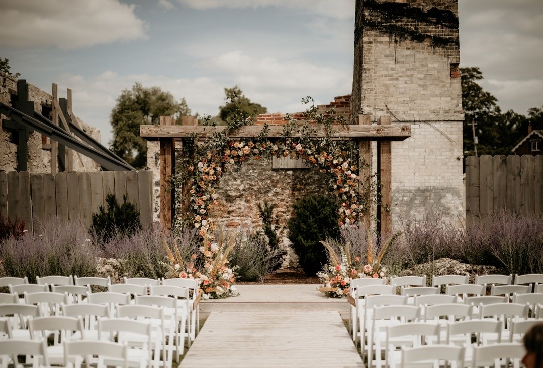 We loved the outdoor ceremony space @elora_mill and while we're sad to see it go, we're glad one of our last ones was THIS beautiful. @Foreverwildfield did an outstanding job making sure bride Michelle's vision of a full floral wreath was successful.