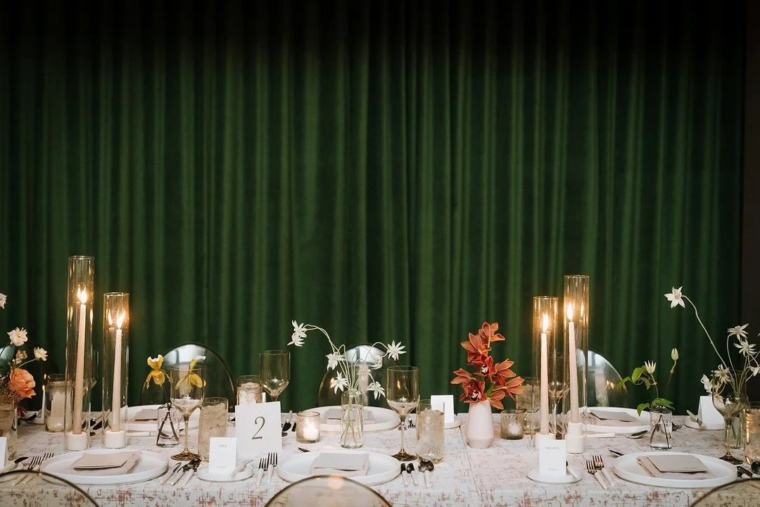 Step inside a romantic late fall wedding reception at Toronto's iconic Gladstone House. B+Q's tablescape features rich, warm reds, tactile velvet etched rose linens, and a glowing ambiance created by warm candlelight and amber-colored glassware. Perf