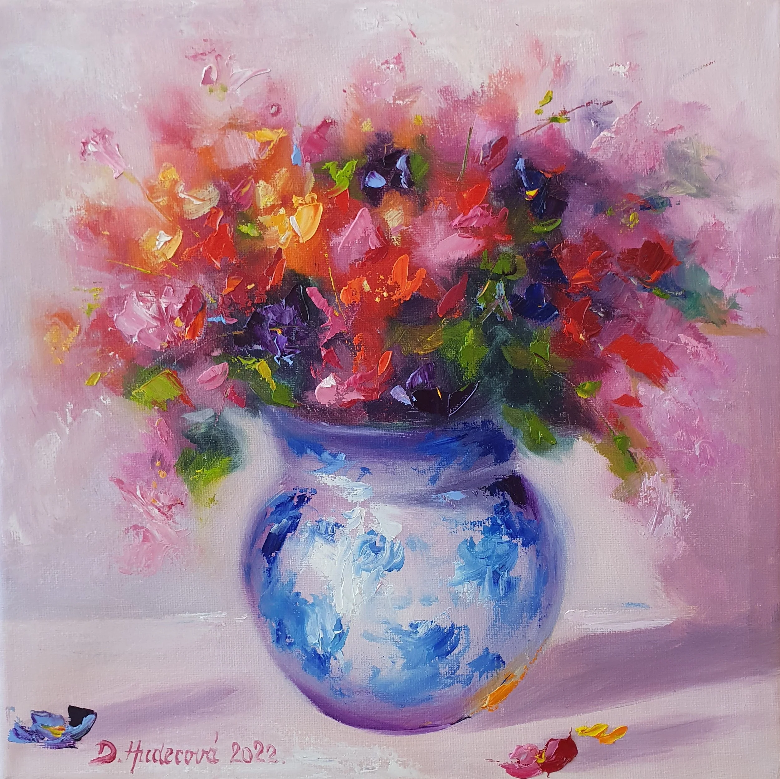 Kytica farebných lúčnych kvetov v porcelánovej váze.