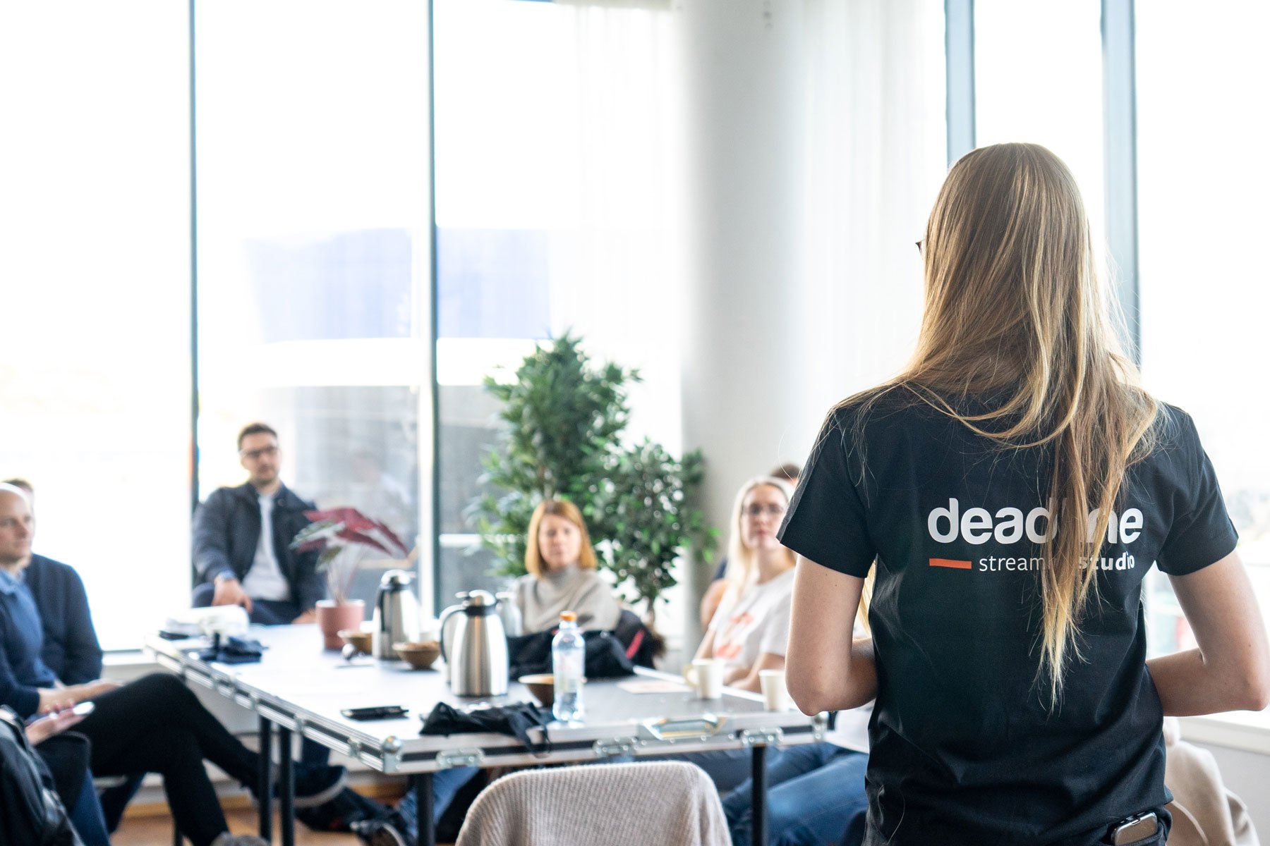 Deadline ansatt snakker til mennesker rundt et bord