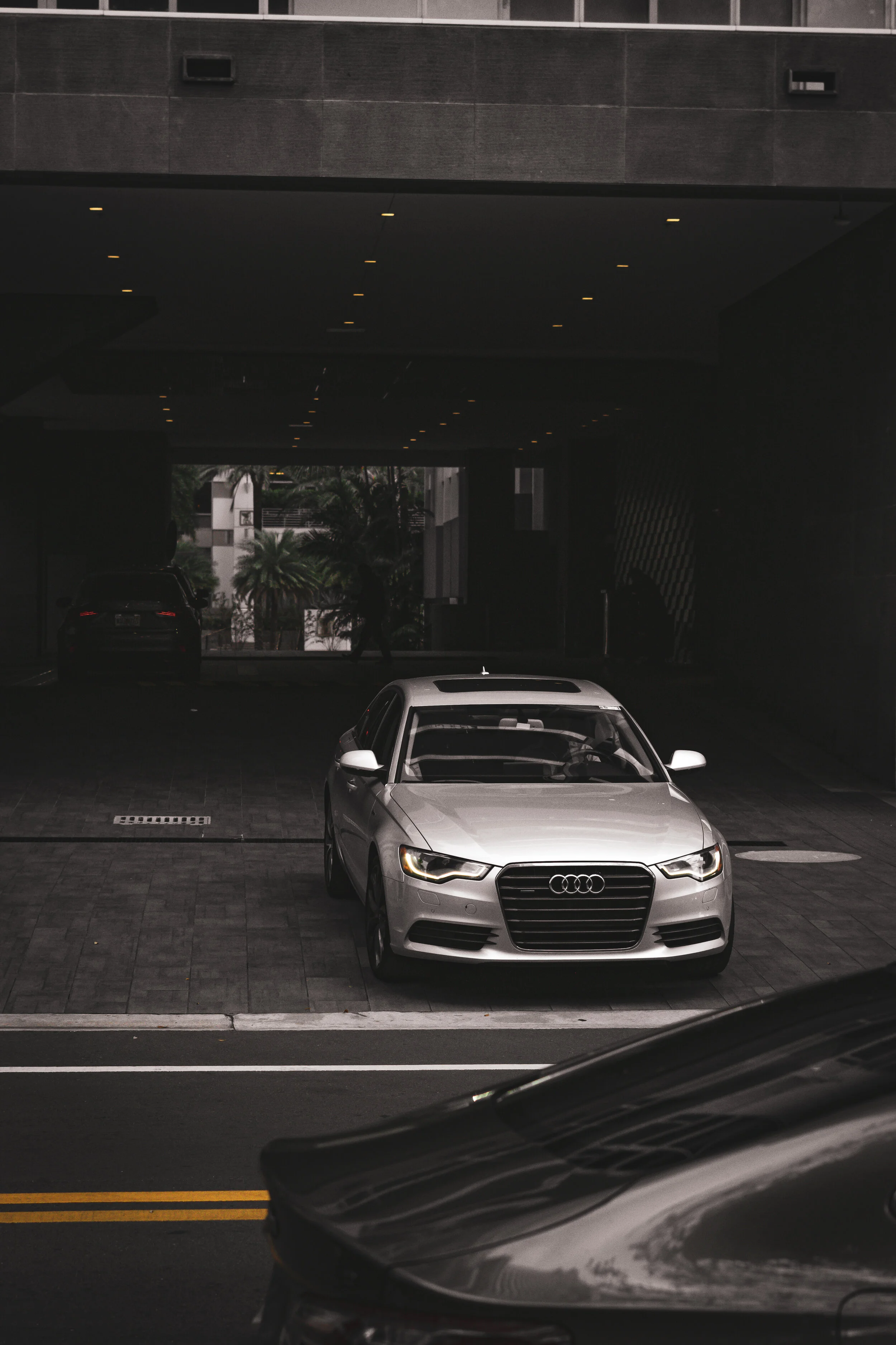 A silver Audi sedan parked in a covered parking garage.