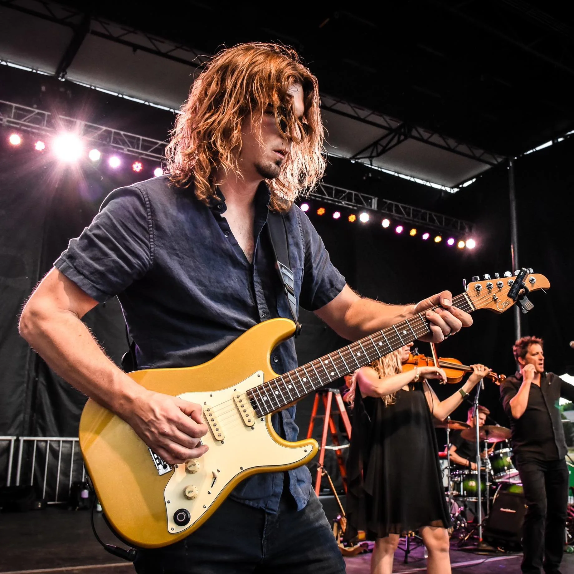 Scott Uhl performing live on electric guitar with touring band on European stage