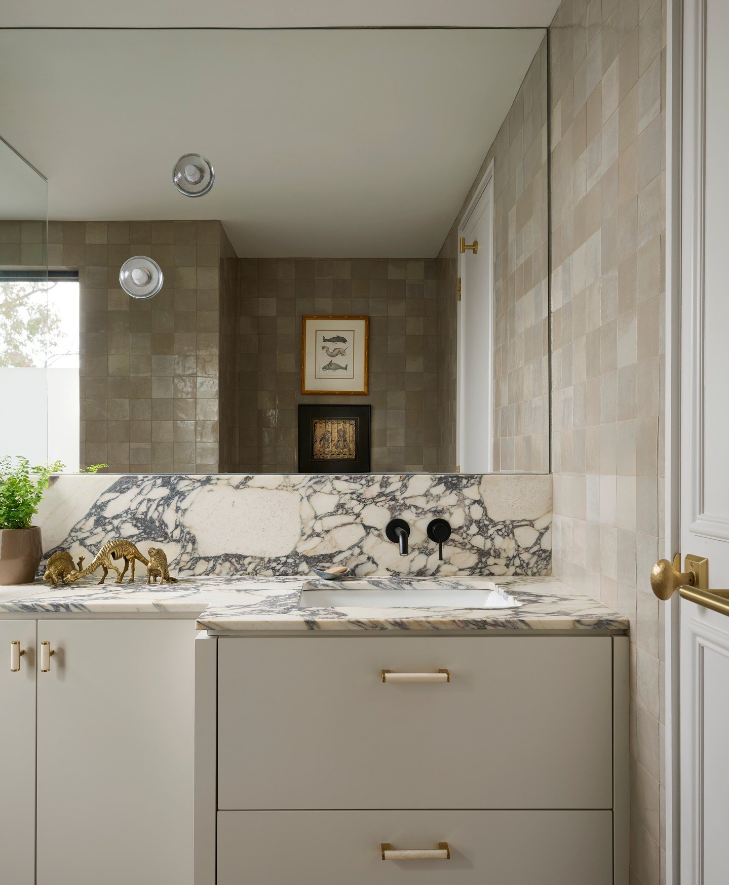 Why does this bathroom feel so good? 

It's the balance. Creamy cabinets and soft neutral zellige tiles keep things calm and easy...then that bold calacatta breccia marble steps in with just the right amount of oomph. 

These are the kind of spaces w
