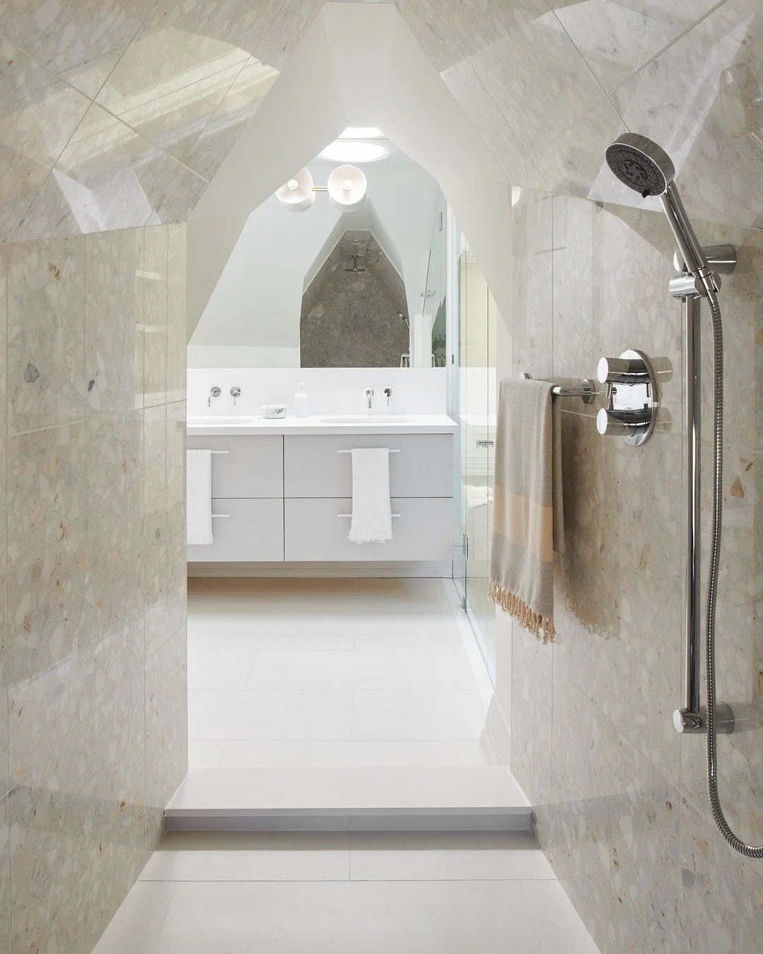 This bathroom is really one of kind. The vaulted ceiling gave us such a strong architectural moment that we decided to emphasize it with terrazzo tiles that wrap the entire space. It makes the room feel cocooned, and I love how the light bounces off 