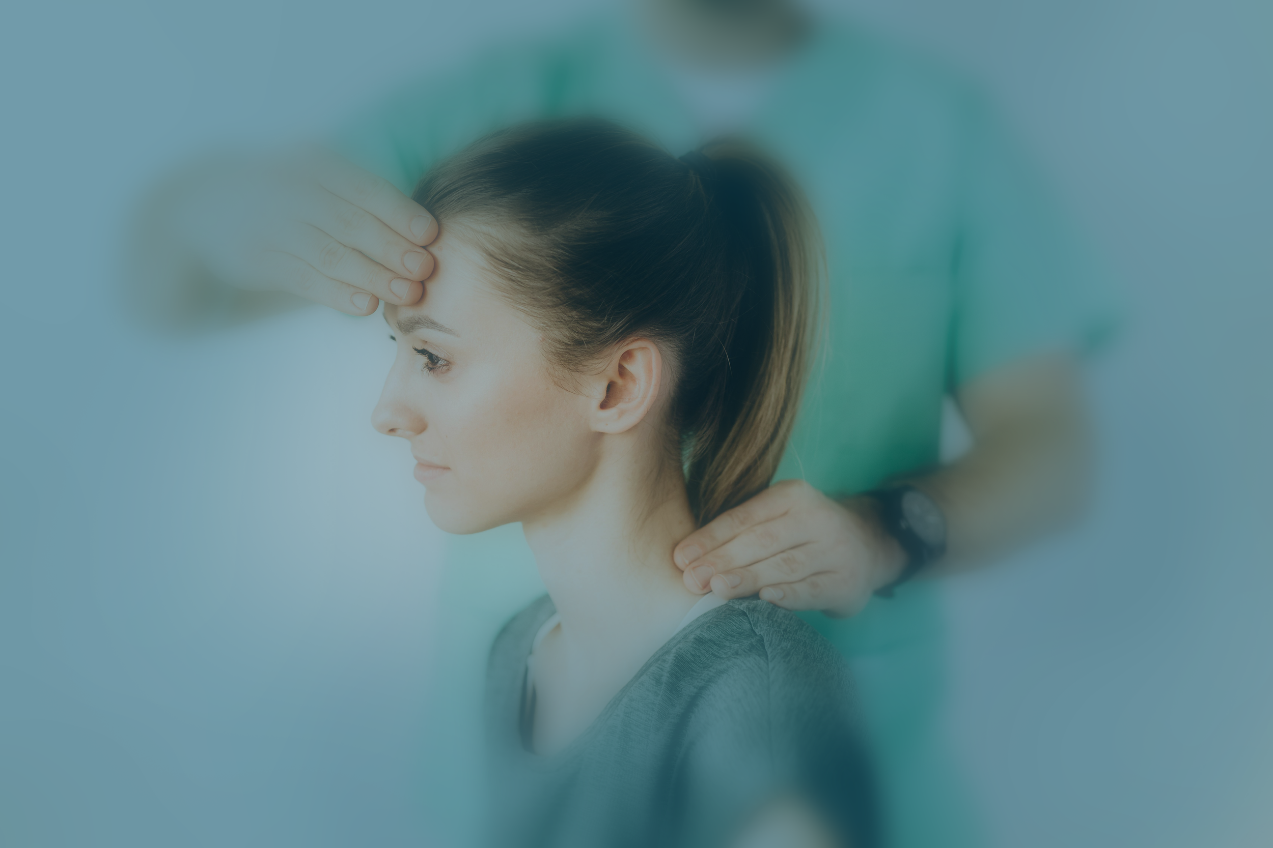 A blue tinted photo of a doctor evaluating a patient's head.