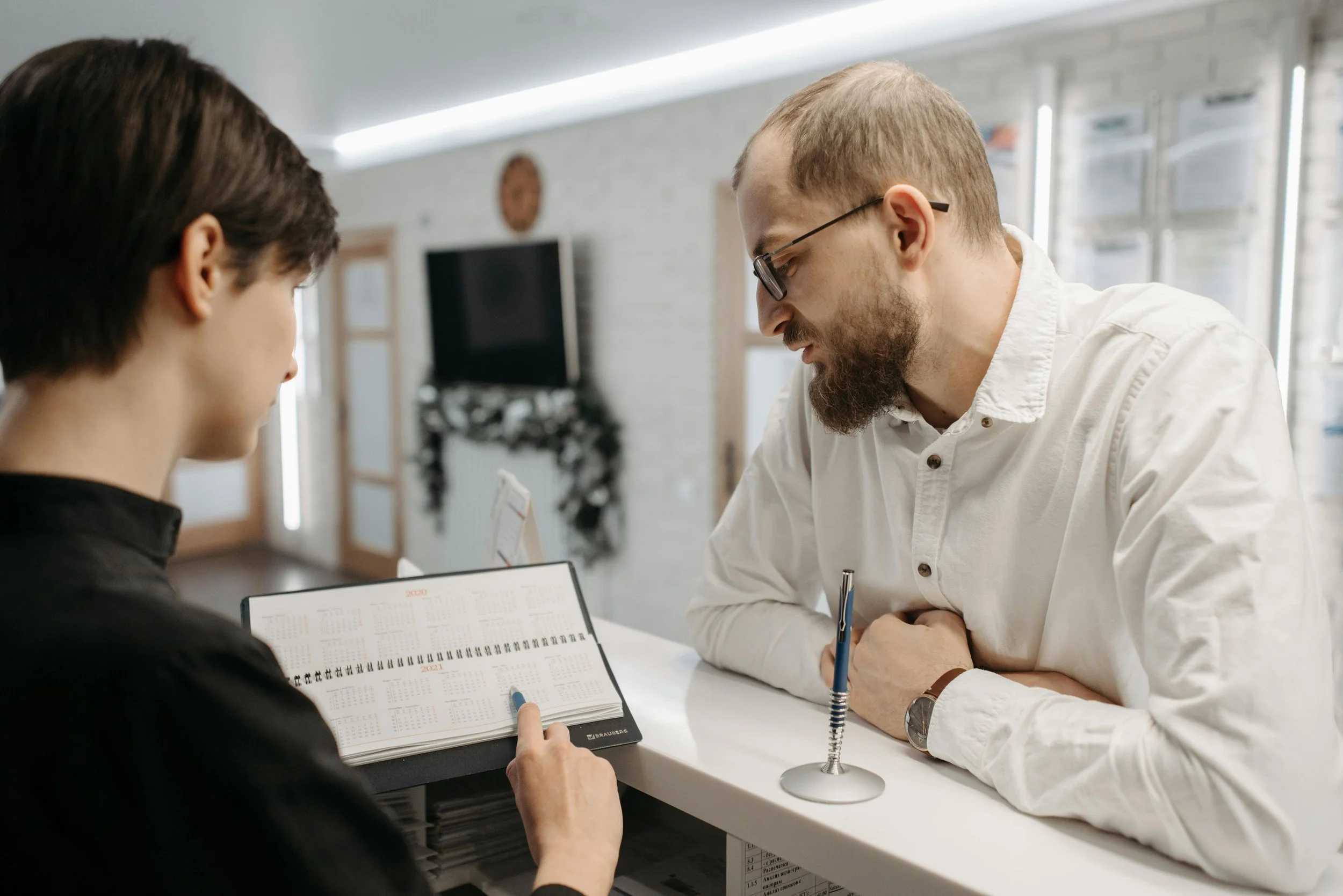 A man making a new patient appointment with a medical front desk worker.