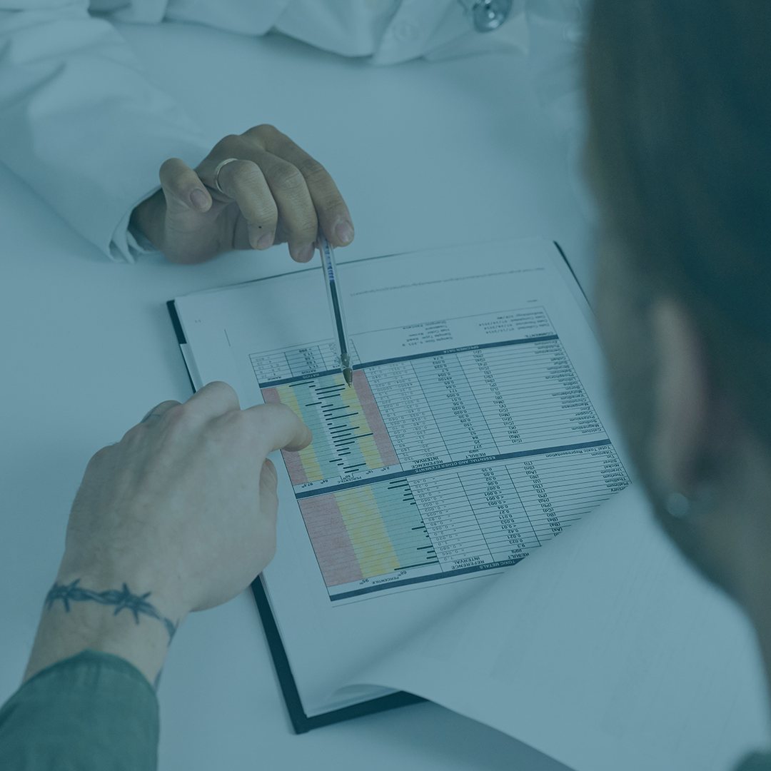 A blue tinted photo of a doctor going over test results with a patient.