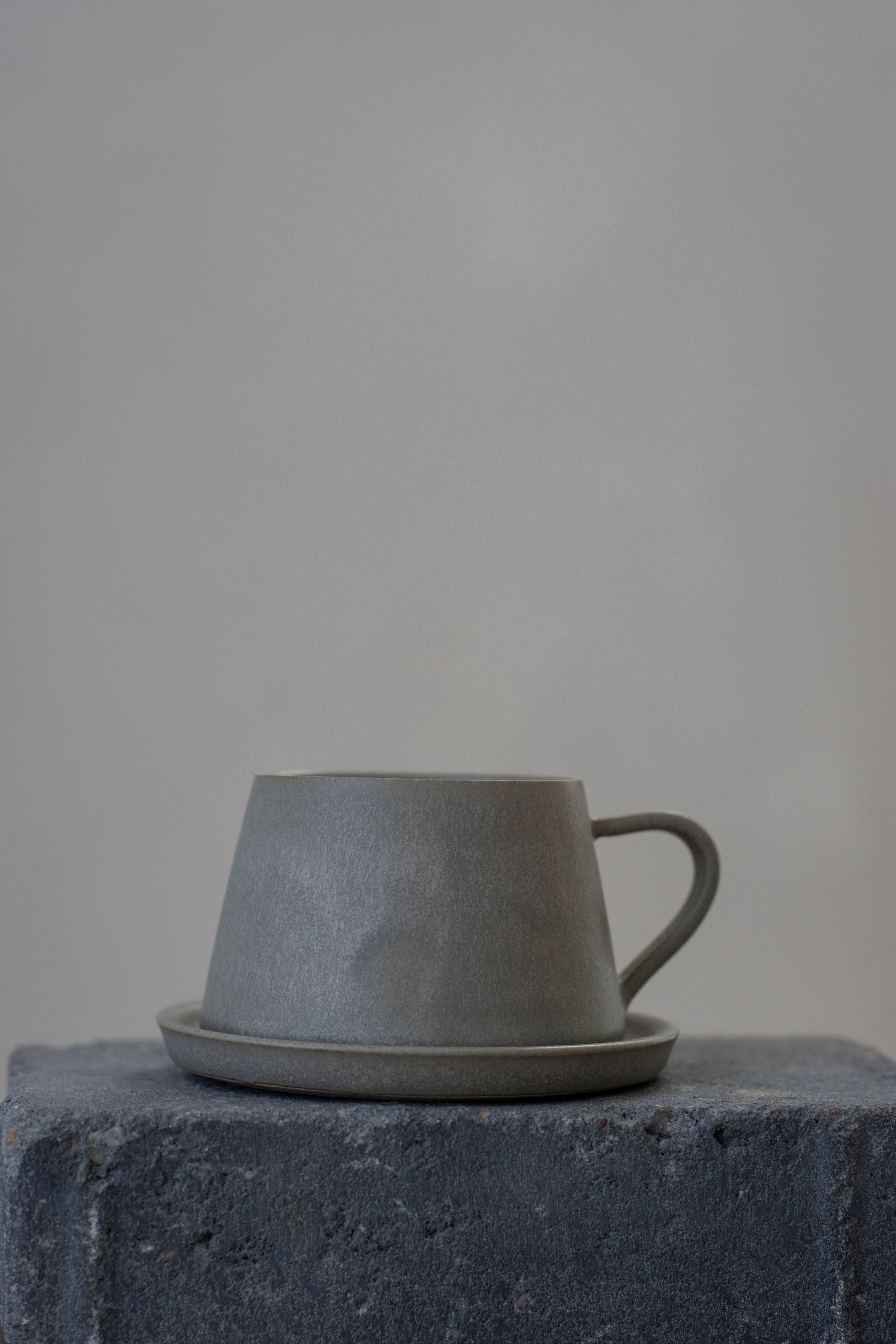Tapered cup and saucer in feather grey
