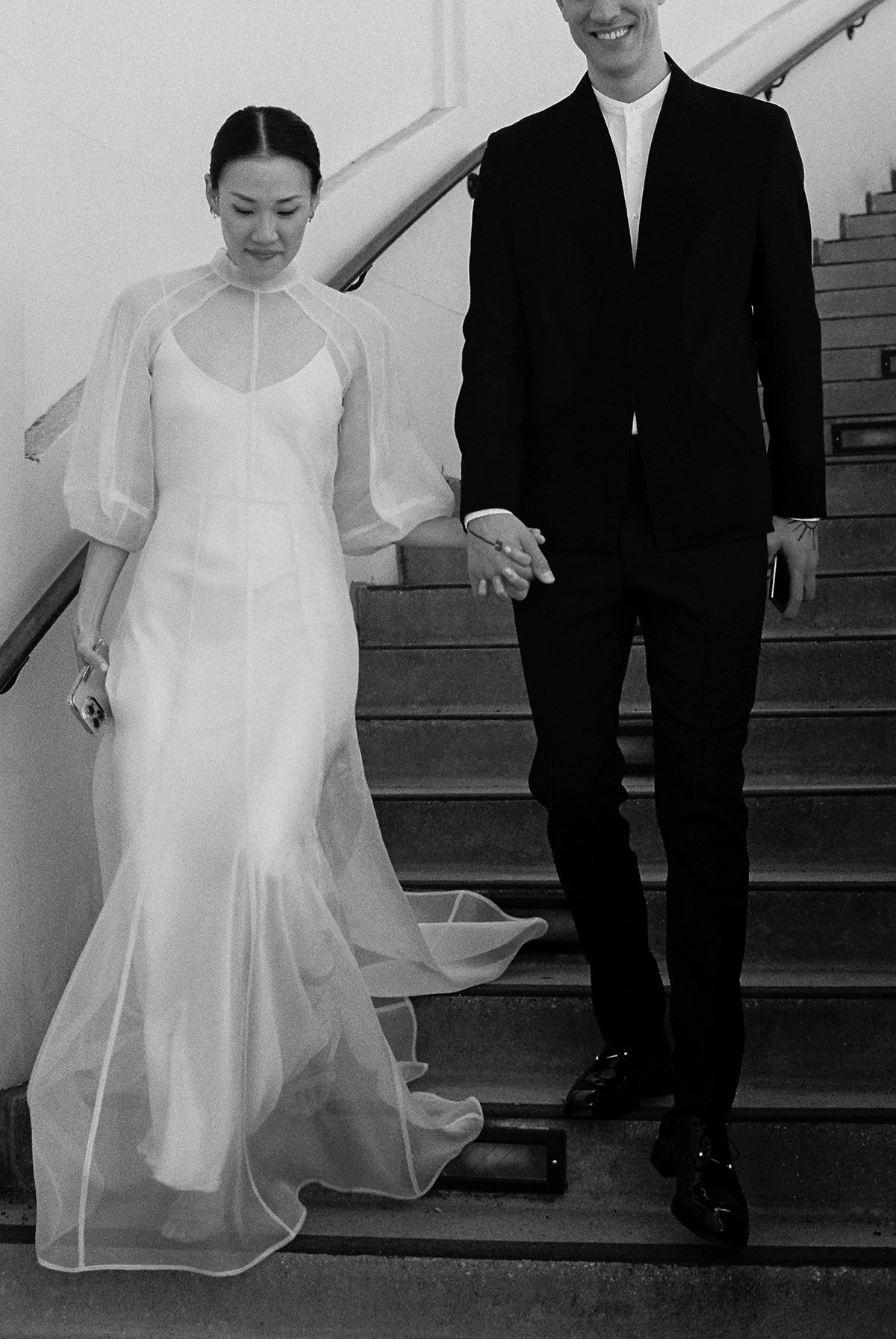  Bride and groom descend the marble staircase inside Beverly Hills City Hall, captured in timeless black and white during their Beverly Hills courthouse wedding appointment. 