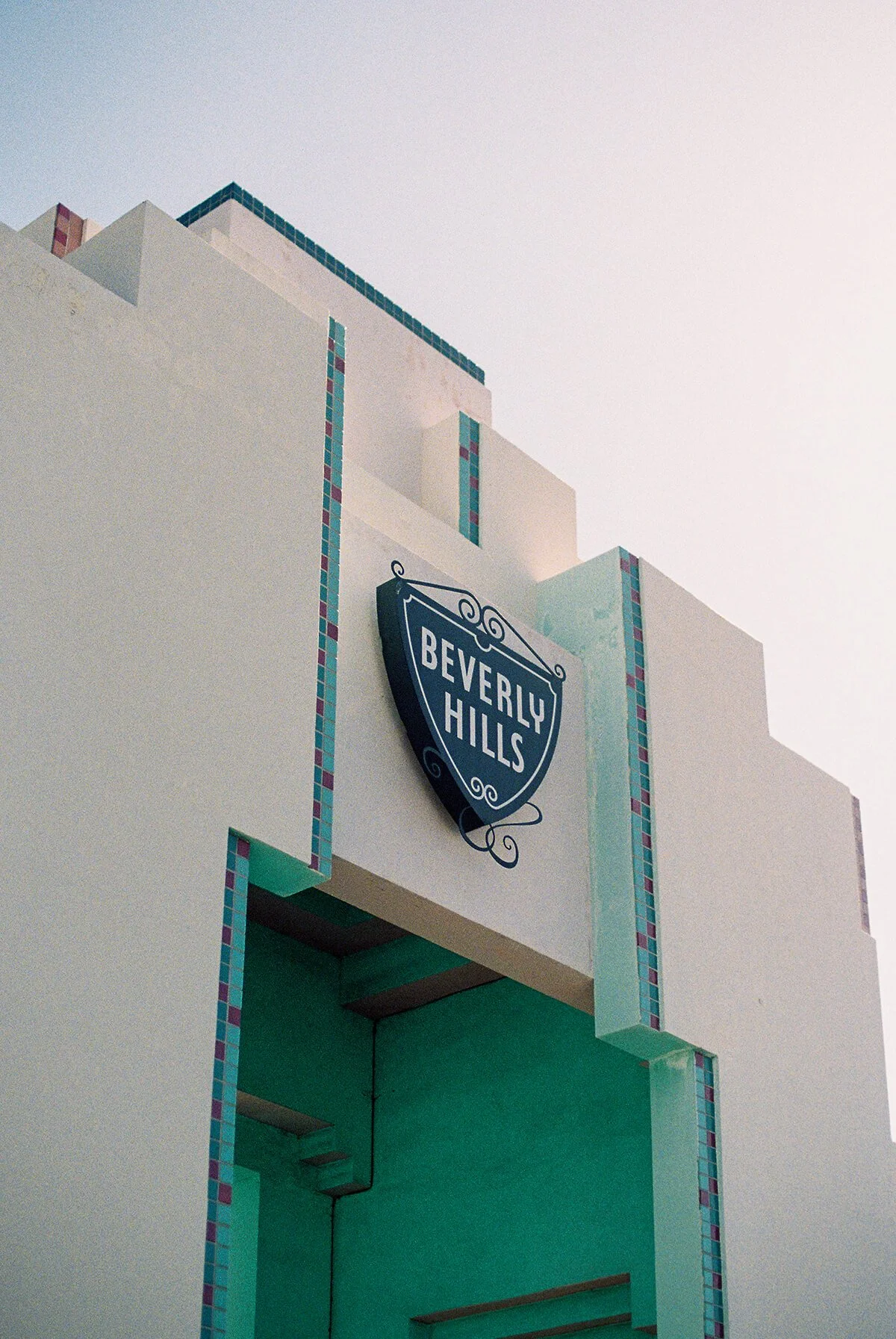  Art deco archway with green, pink, and teal tile accents beneath the iconic Beverly Hills sign outside Beverly Hills City Hall, often photographed before or after a Beverly Hills courthouse wedding. 