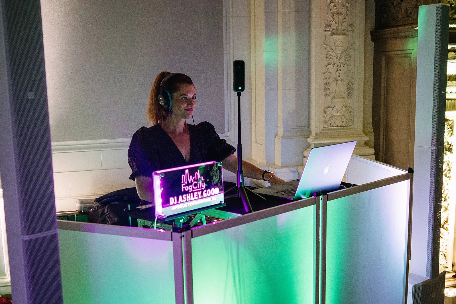 DJ Ashley in her DJ booth with dynamic and uplighting