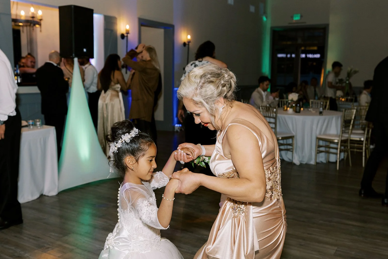 Woman dancing with young girl on wedding dance floor