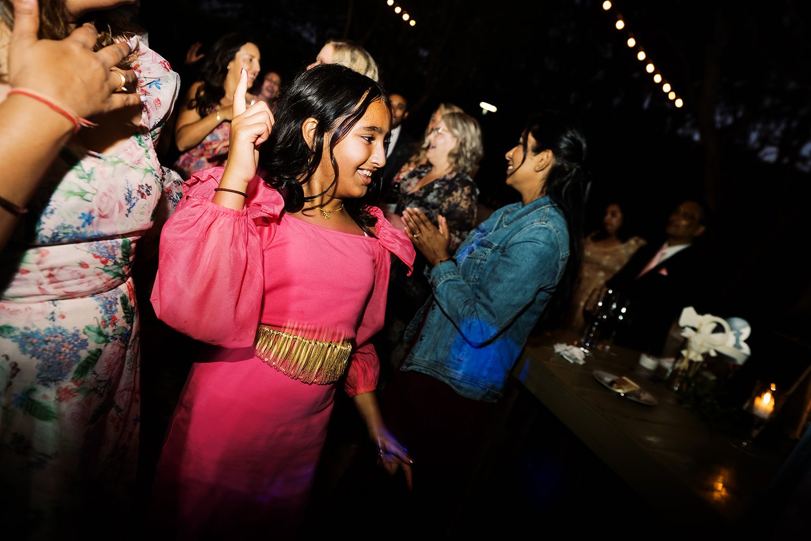 Candid moment of guests dancing at a multicultural wedding reception