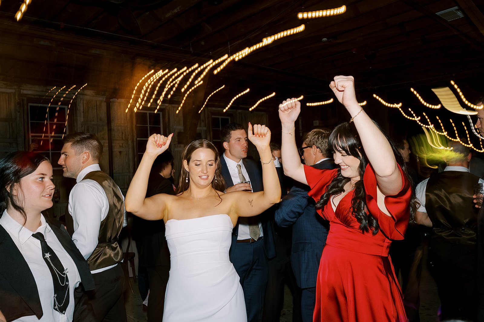 Bride dancing with guests on a lively wedding dance floor led by a wedding DJ