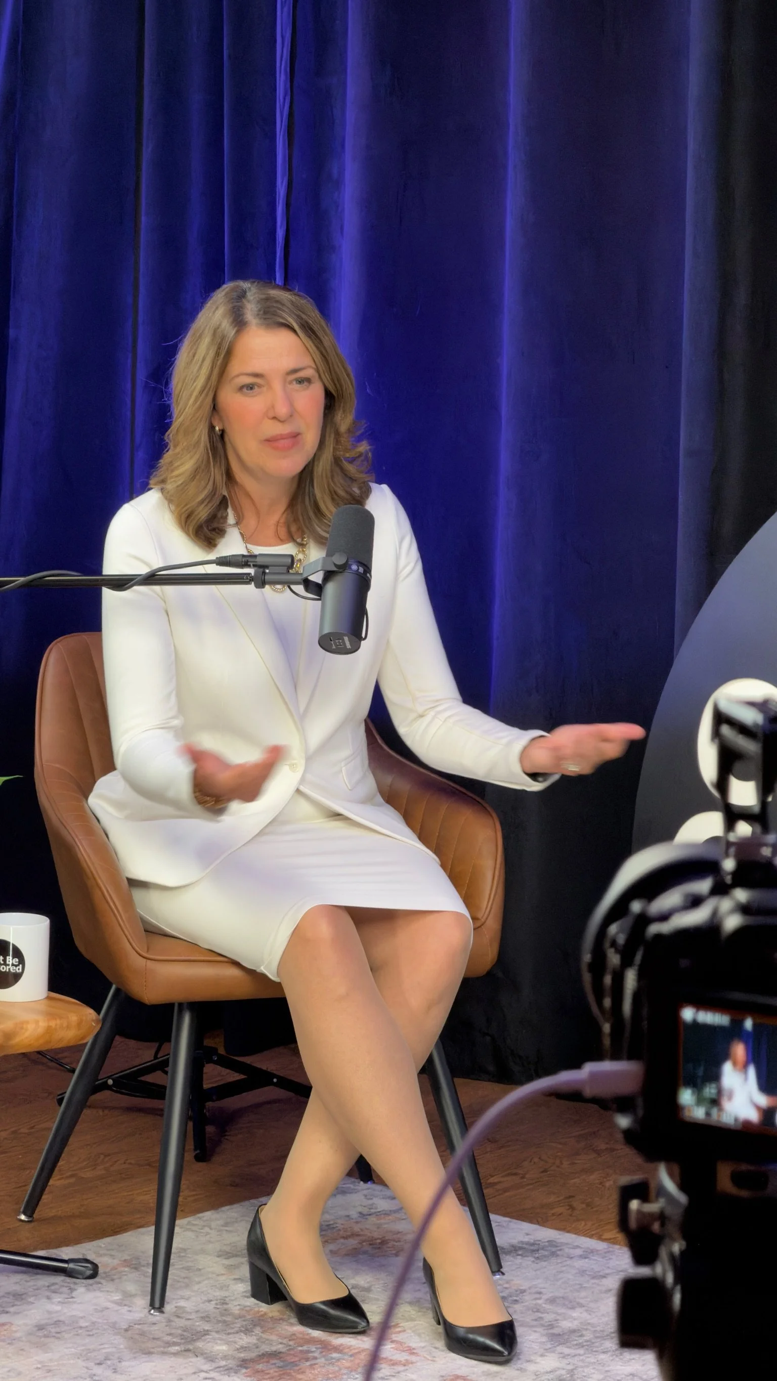 Alberta Premier Danielle Smith podcasting in our studio with black curtain backdrops