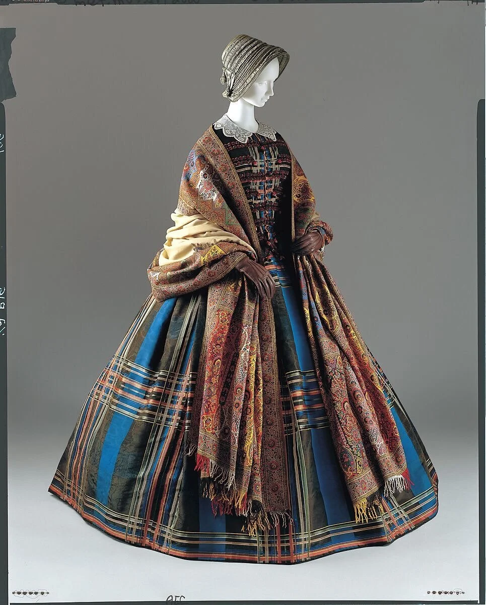 This rather lovely 1857 plaid, silk gown from the @metmuseum has been imaginatively paired with a lace collar, leather gloves and a finely woven Indian shawl by a clever curator. The ensemble offers a useful reminder that our modern preoccupation wit