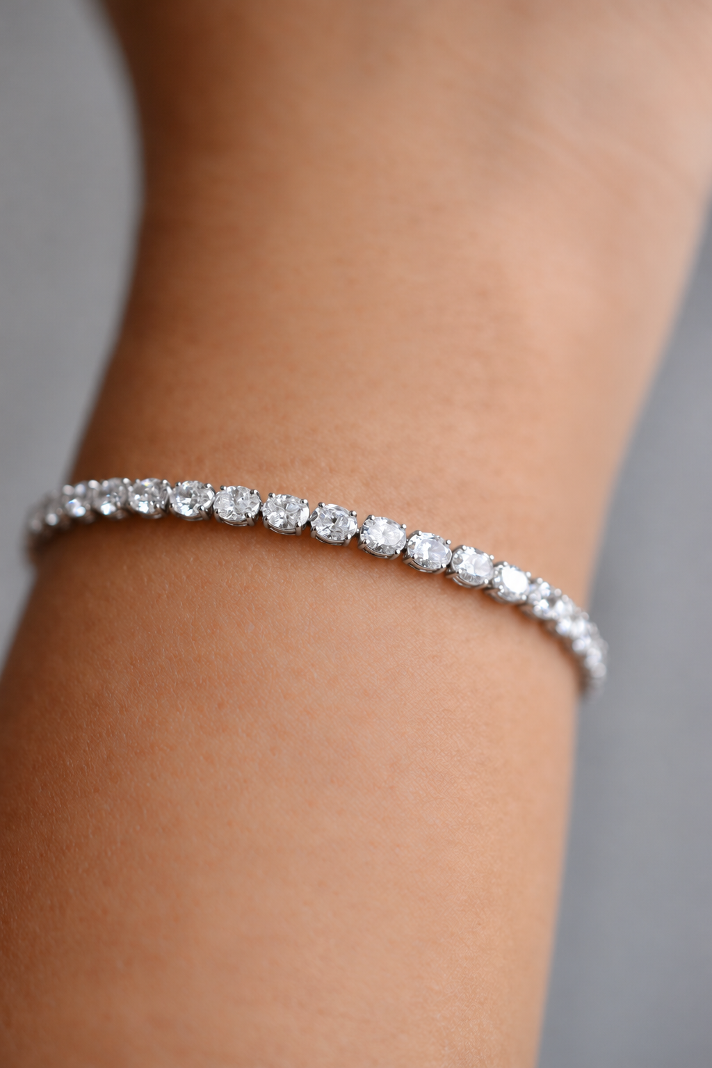 Colette east-west oval diamond tennis bracelet in white gold, worn on the wrist, by August Bespoke Singapore