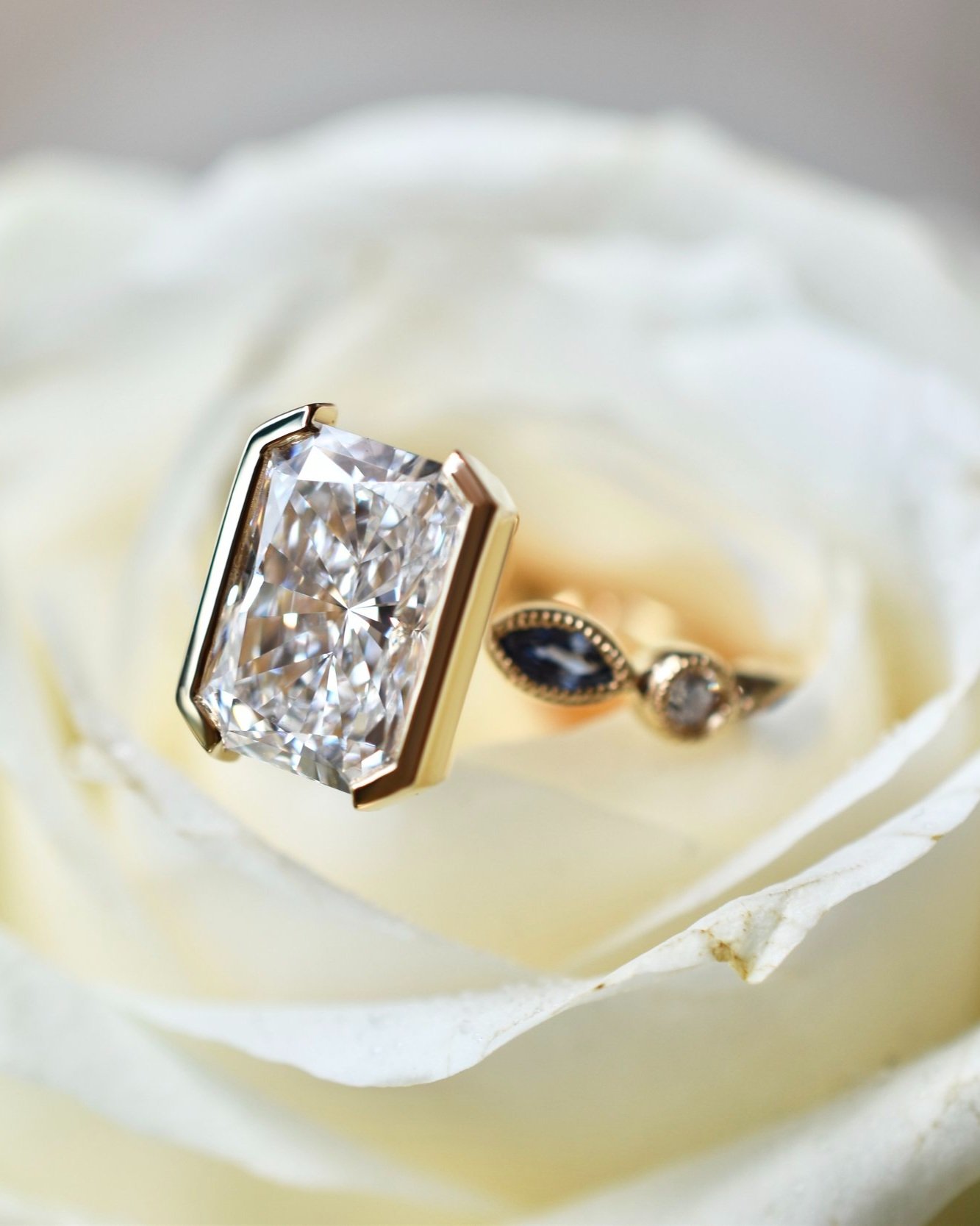 Radiant Cut Engagement Ring with Half Bezel and Blue Sapphire Marquise