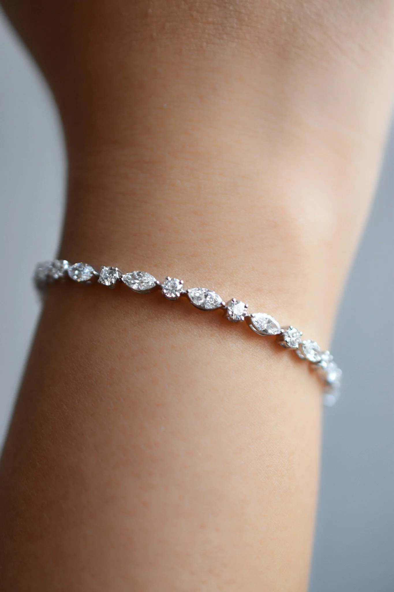 Élodie diamond bracelet in white gold with round and marquise diamonds, worn on the wrist, by August Bespoke Singapore