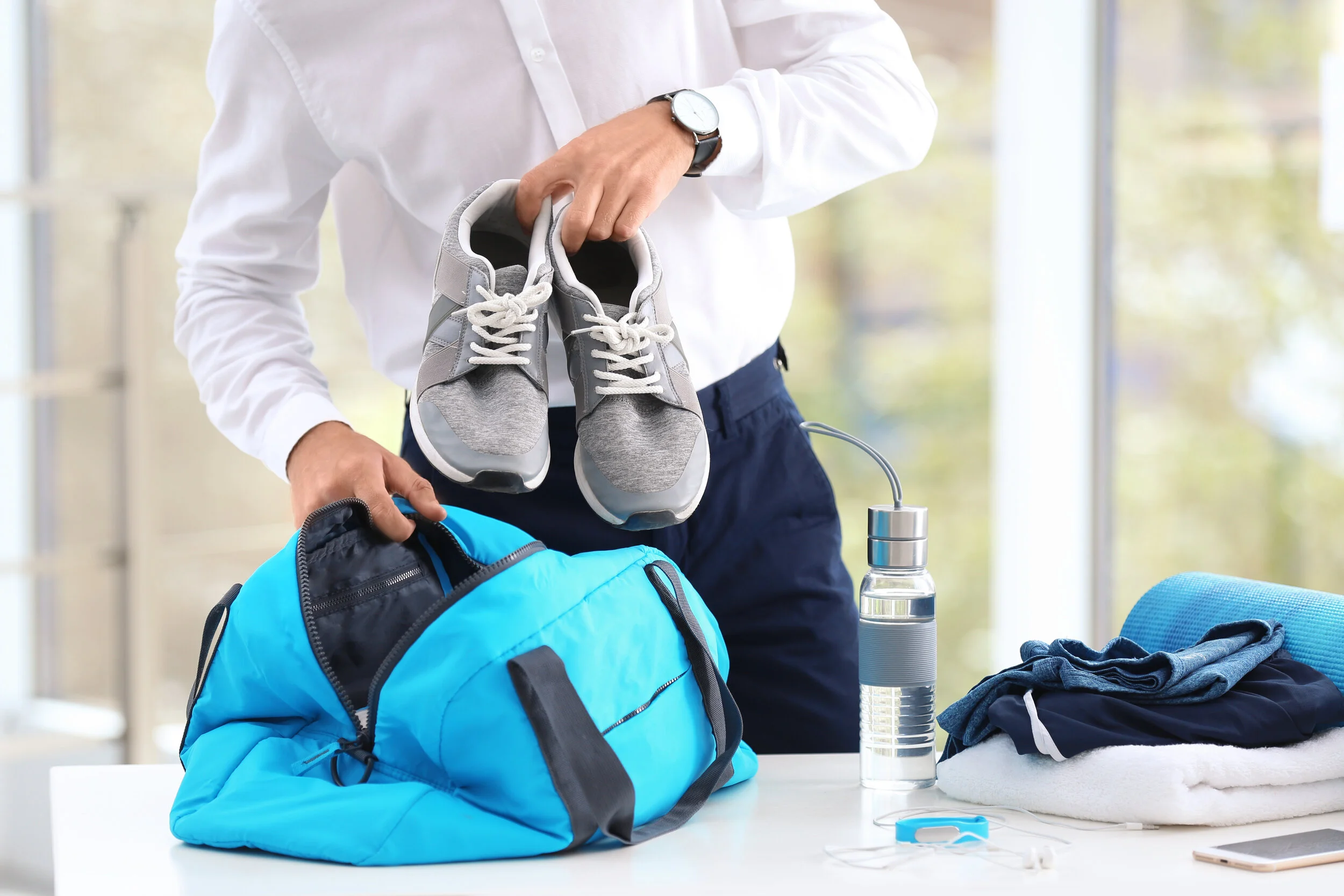 Man putting gym shoes into bag