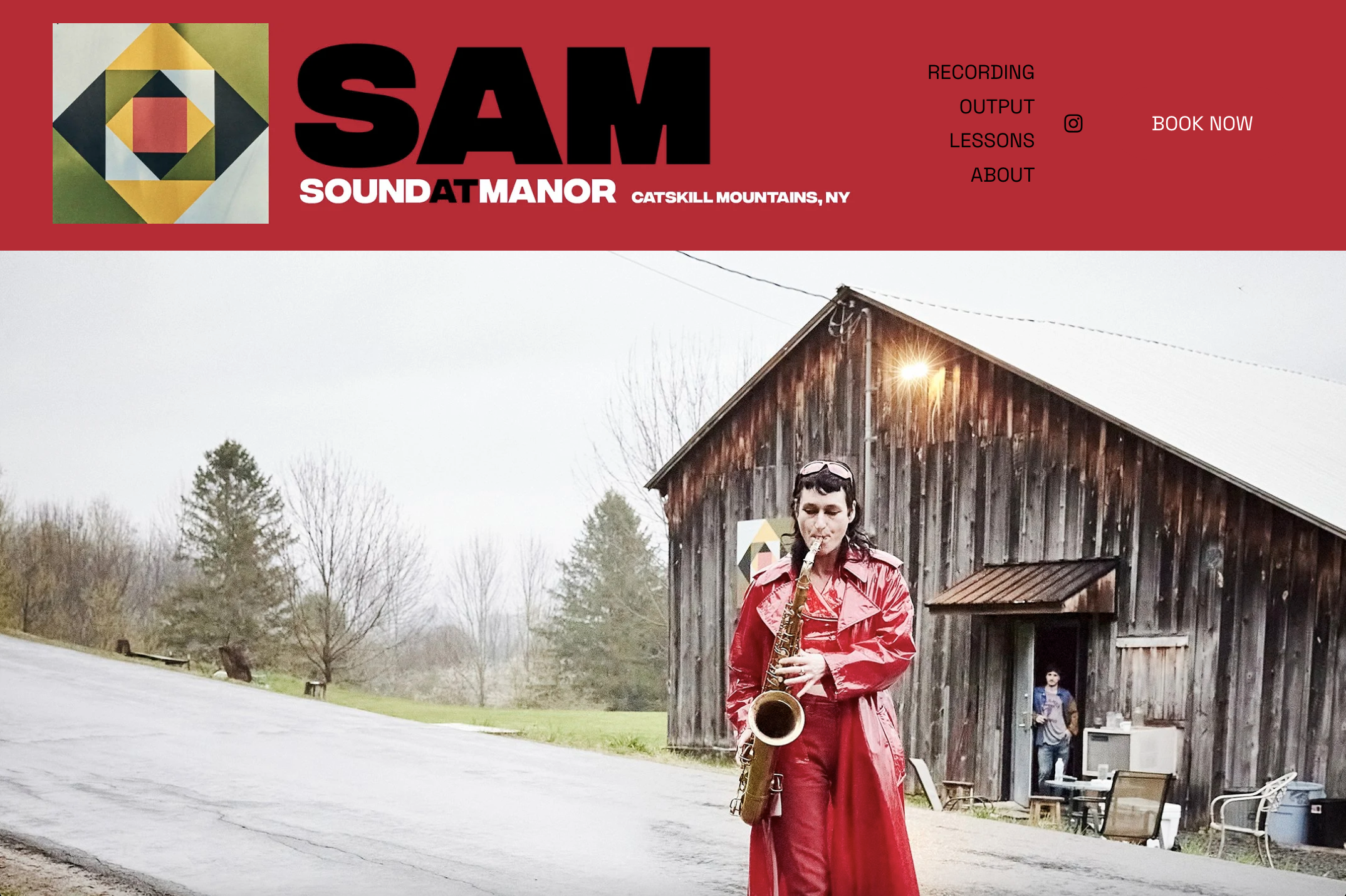 A woman in a red coat playing a saxophone outside a wooden barn with a man standing inside the barn near a computer and a chair.