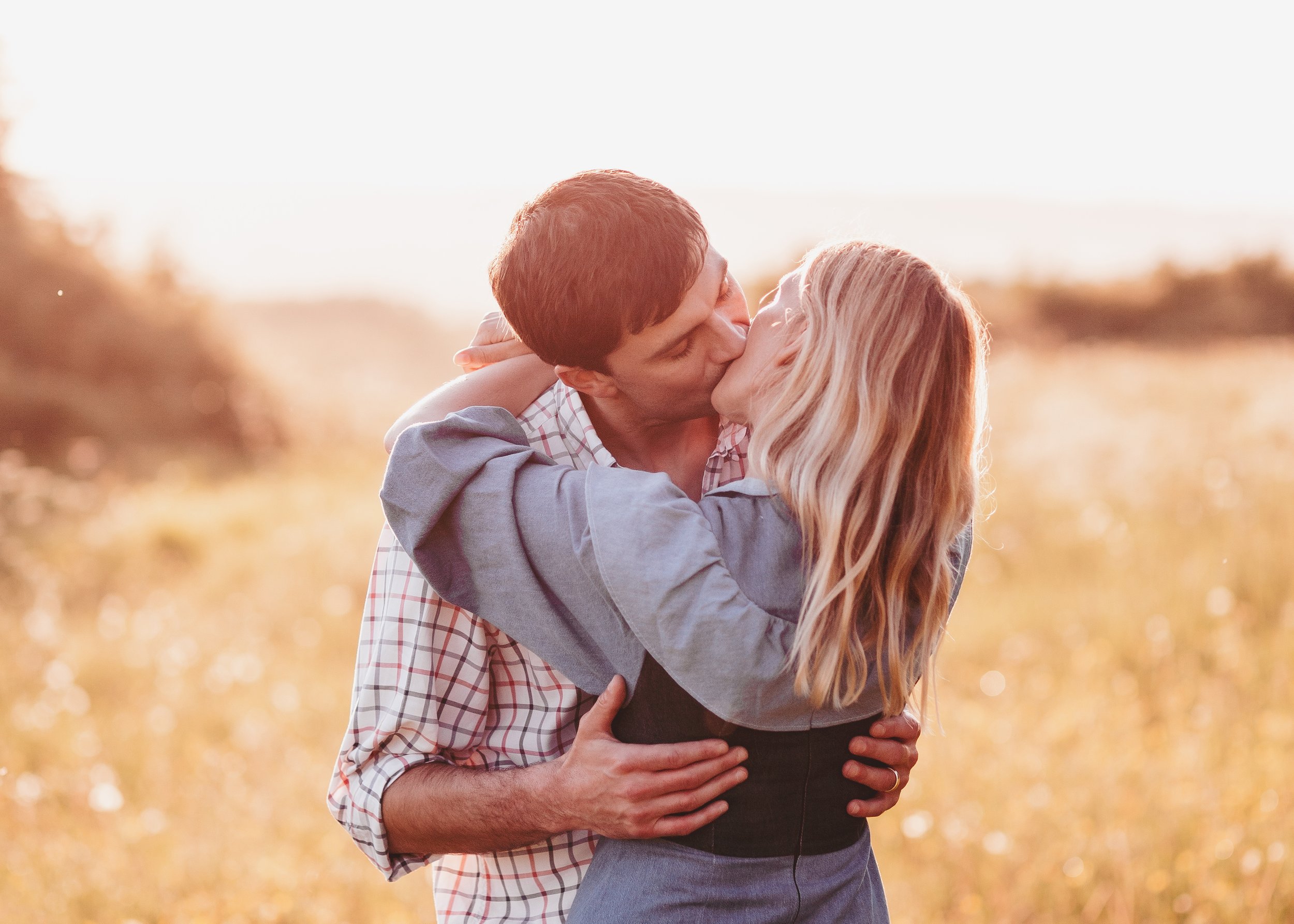 Intimate couples engagement photography in a wildflower field in The Cotswolds at sunset
