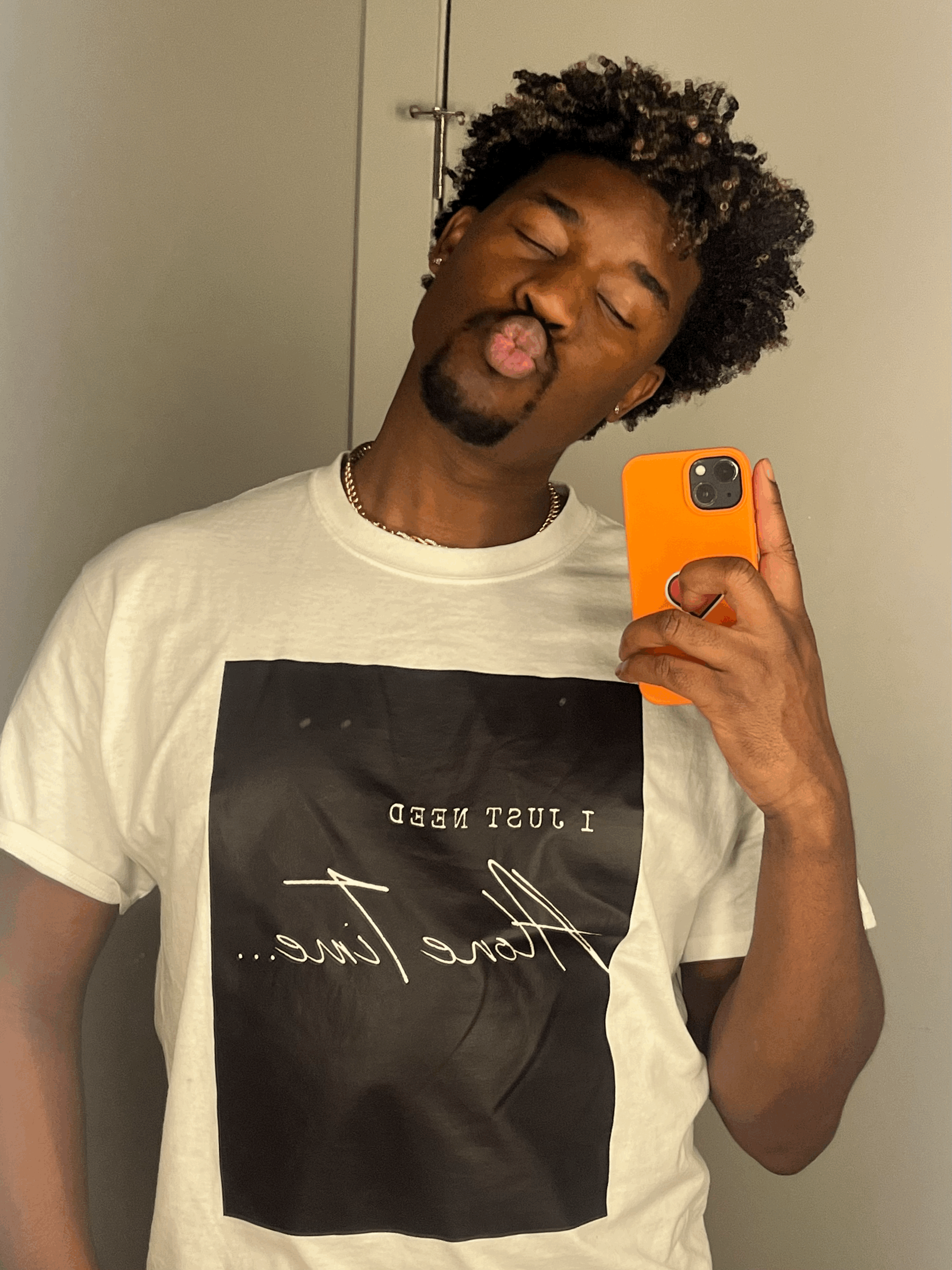 Joseph Valenté makes a kissy face wearing the black and white Alone Time t shirt with a graphic that says I Just Need Alone Time