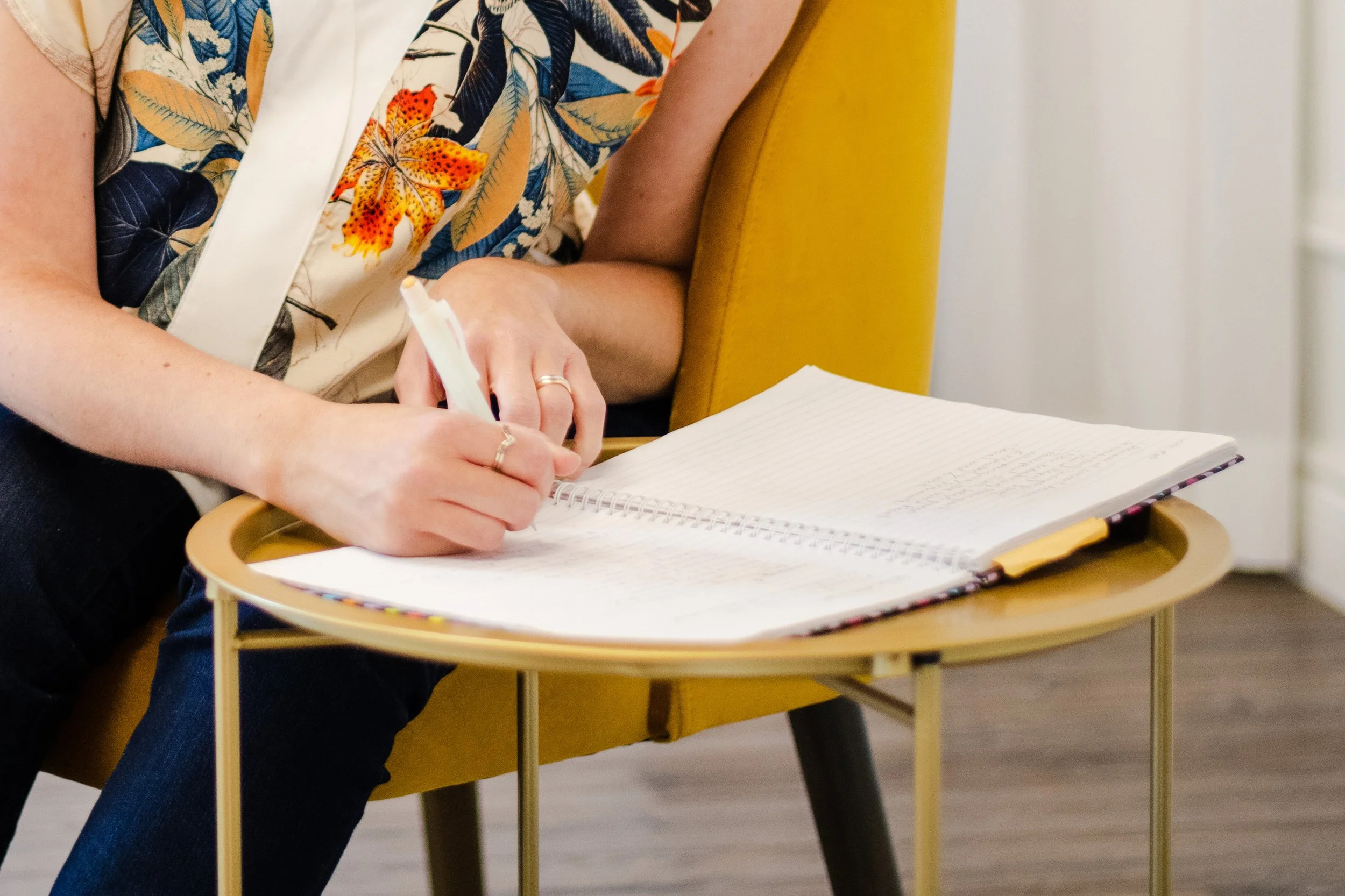A close-up of Michelle's hands while she is writing in a notebook.