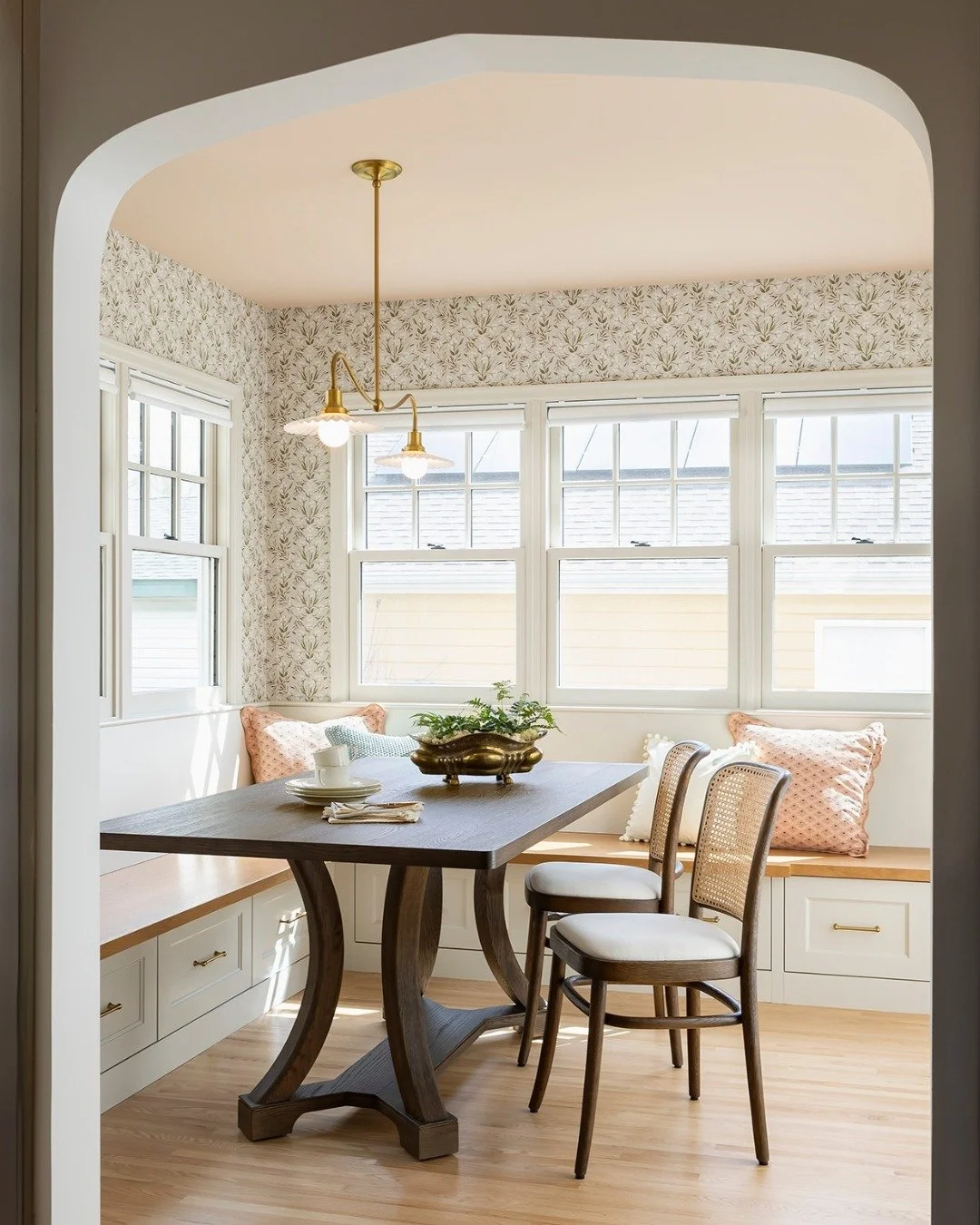 We love this peek inside a former three season porch turned dining room in our Portland project. 👀⁣
⁣
This sun-filled space is bright all throughout the day, the perfect place for a quiet night at home. A cozy banquette, sweet floral wallpaper, and 