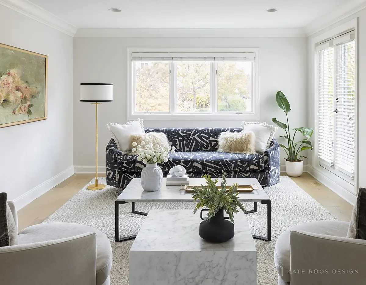 This airy and inviting living room by Kate Roos Design, an esteemed interior designer in Minneapolis, balances modern sophistication with everyday comfort. A soft neutral palette, layered with rich leathers, textured upholstery, and organic forms, cr
