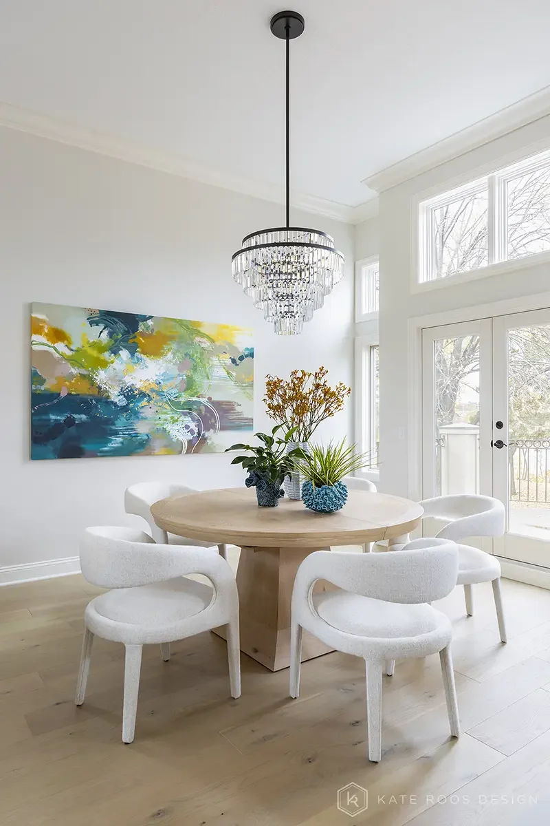 This airy and inviting living room by Kate Roos Design, an esteemed interior designer in Minneapolis, balances modern sophistication with everyday comfort. A soft neutral palette, layered with rich leathers, textured upholstery, and organic forms, cr