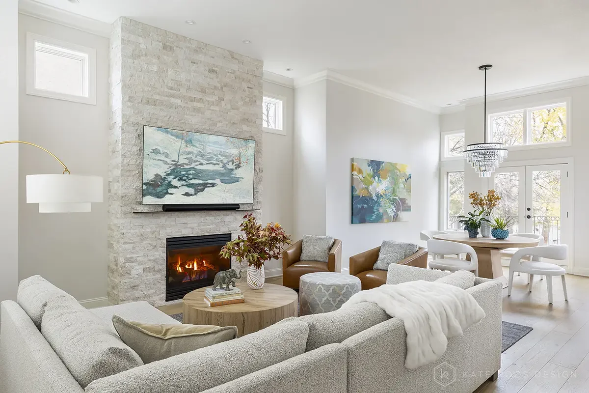 This airy and inviting living room by Kate Roos Design, an esteemed interior designer in Minneapolis, balances modern sophistication with everyday comfort. A soft neutral palette, layered with rich leathers, textured upholstery, and organic forms, cr