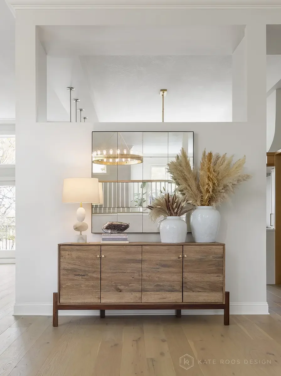 This airy and inviting living room by Kate Roos Design, an esteemed interior designer in Minneapolis, balances modern sophistication with everyday comfort. A soft neutral palette, layered with rich leathers, textured upholstery, and organic forms, cr