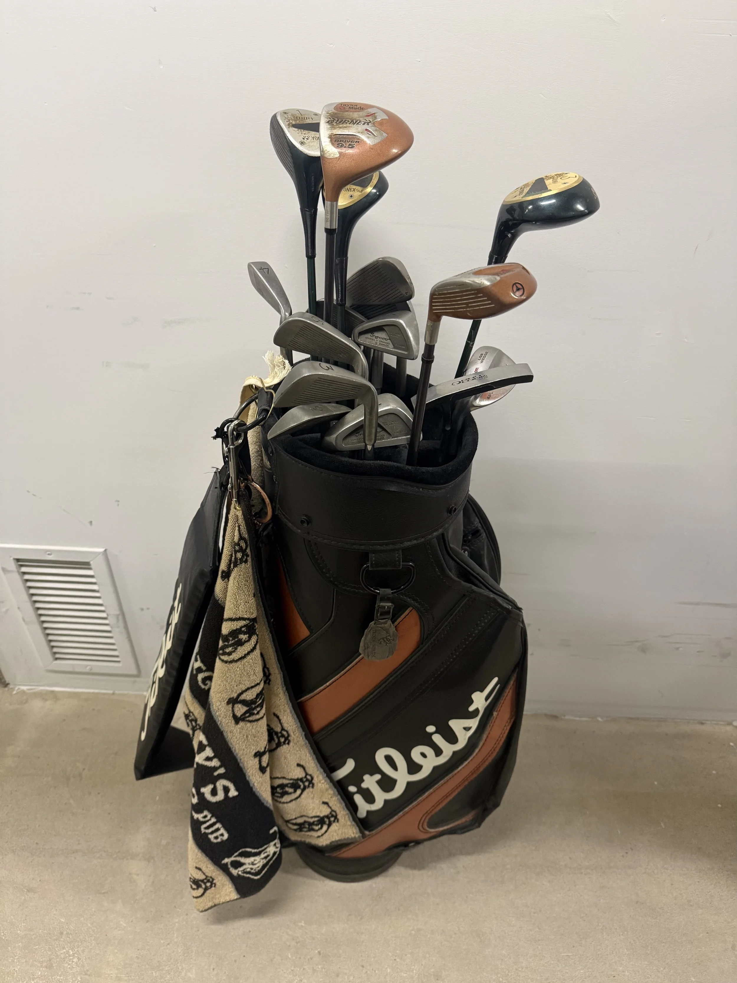 135.  Yonex 1,3,5 woods, Taylor Made 7 & 9.5 drivers, 9 irons, pitching wedge, lob wedge, sand wedge, putter in Titleist golf bag