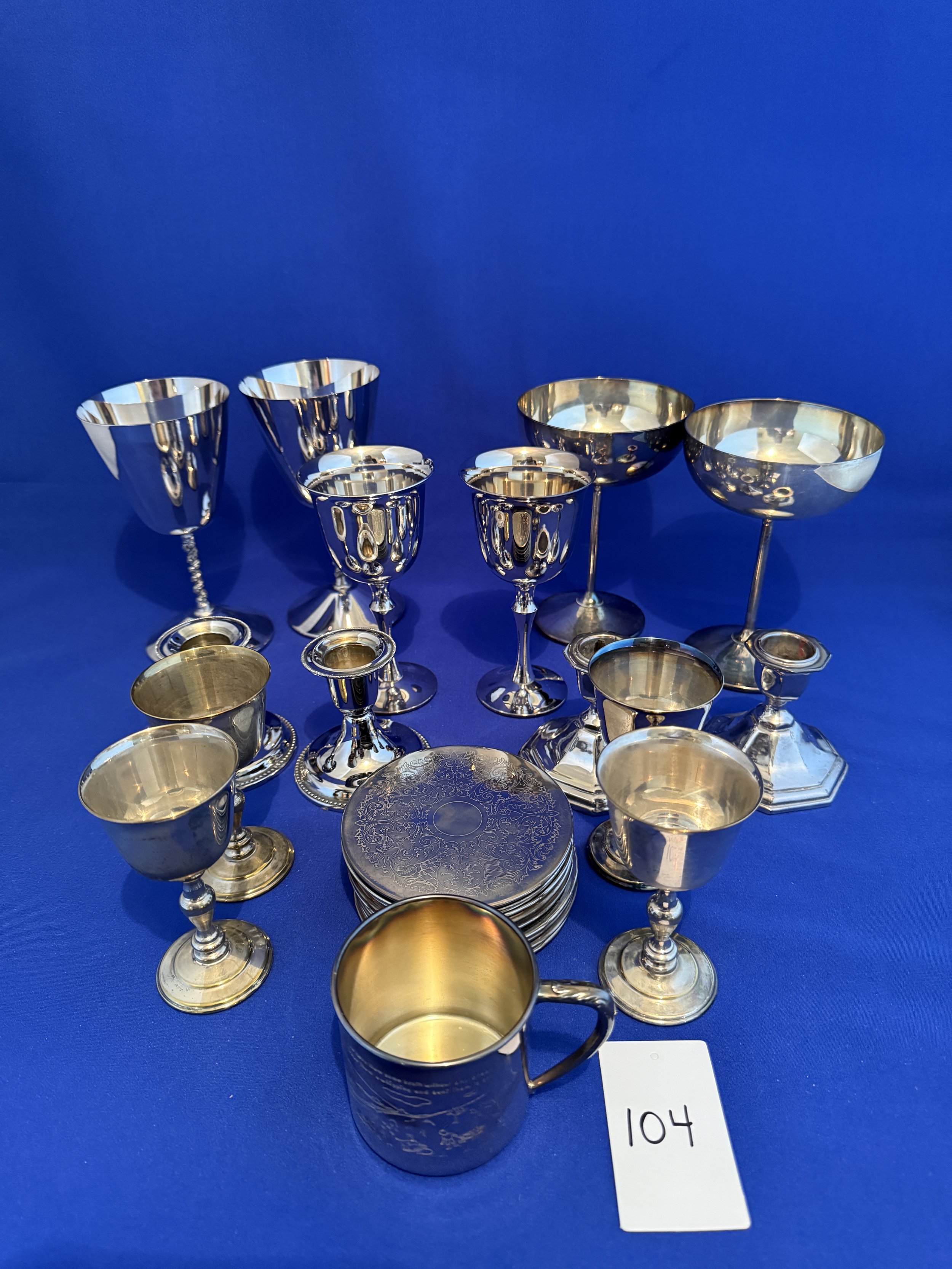 104. Selection of silver plated items including goblets, candle stands, coasters, champagne glasses and baby mug, talles 6"