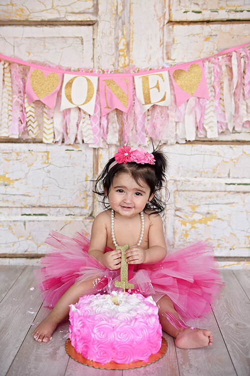 Baby girl with balloons at cake smash photoshoot in Orange County CA