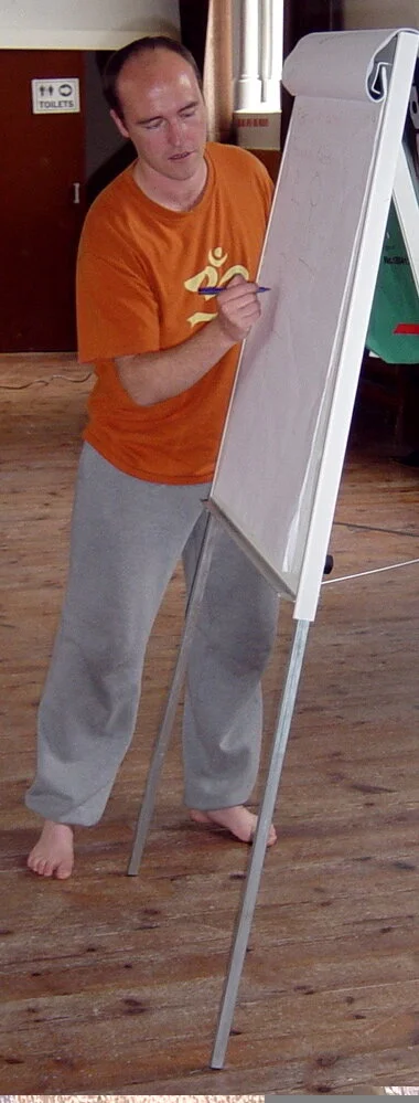 Person writing on a flip chart in a casual setting.