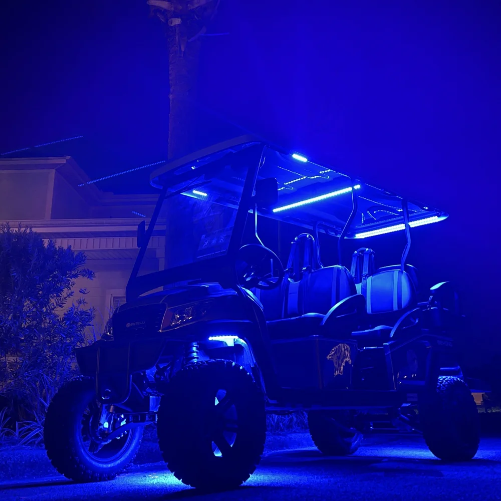 Lifted 6 seat street legal golf cart with blue LED underglow at night in Miramar Beach