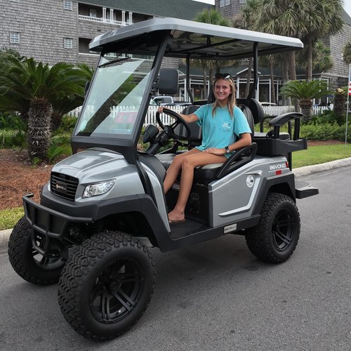 Rider enjoying the lifted titanium 4-seat golf cart