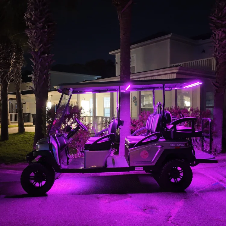 6-seat lifted golf cart with purple LED underglow at night