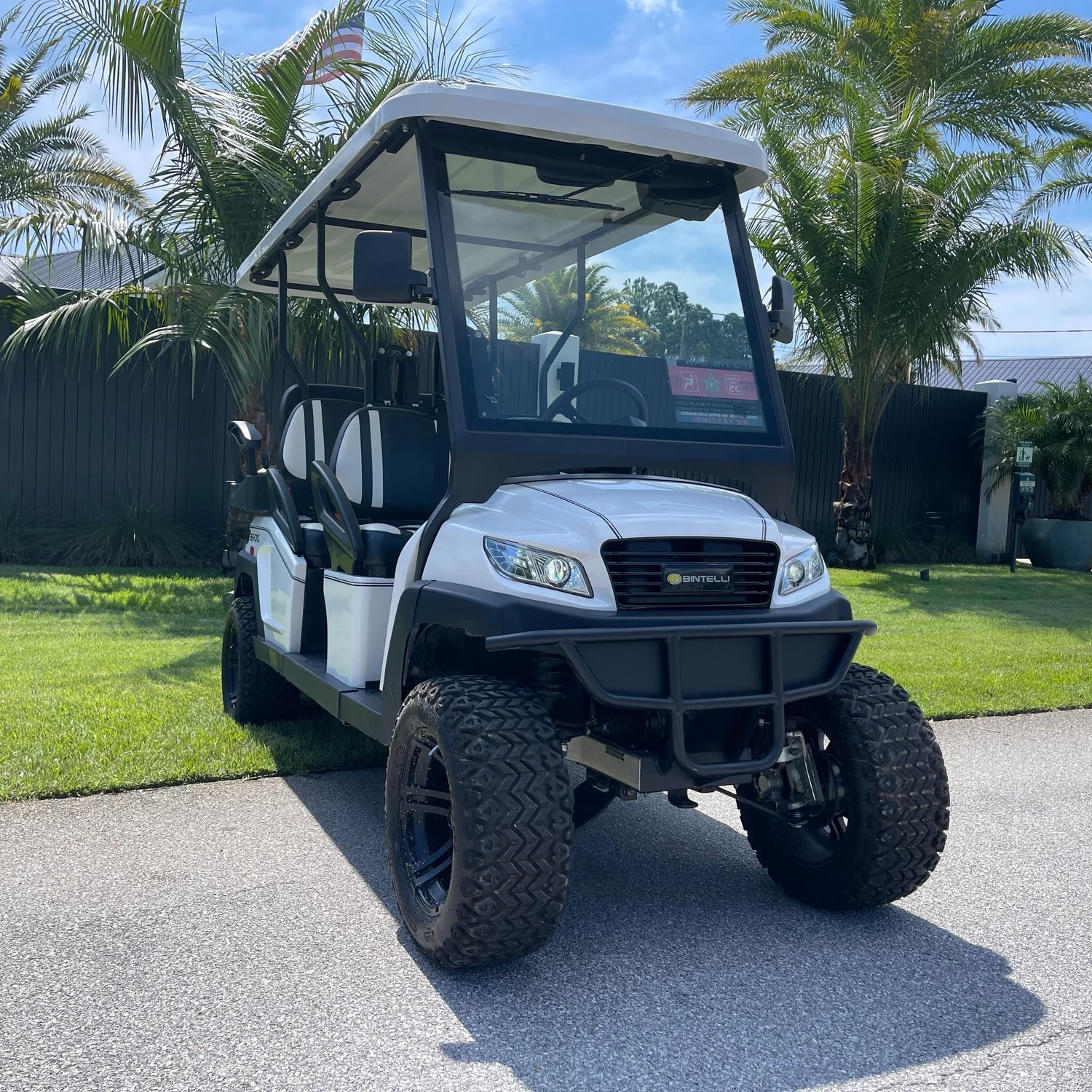 LWB45L white lifted 6 seat electric street legal golf cart LSV parked on the Emerald Coast