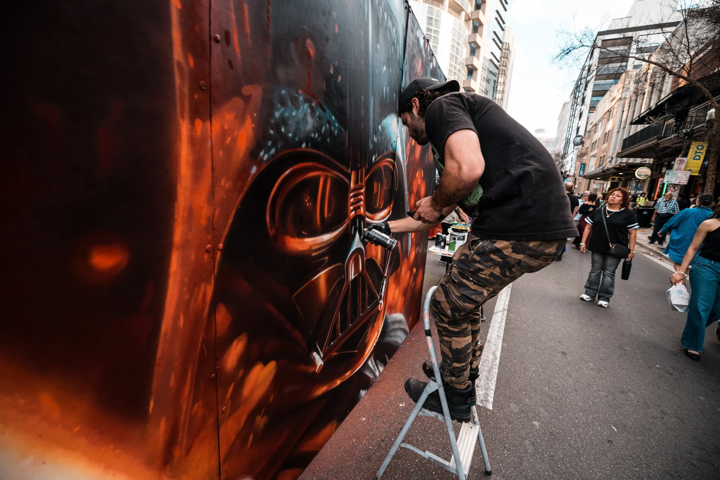 A visual artist from the Walls of Pho Hoa paints a mural at IMMERSE in Downtown Orlando