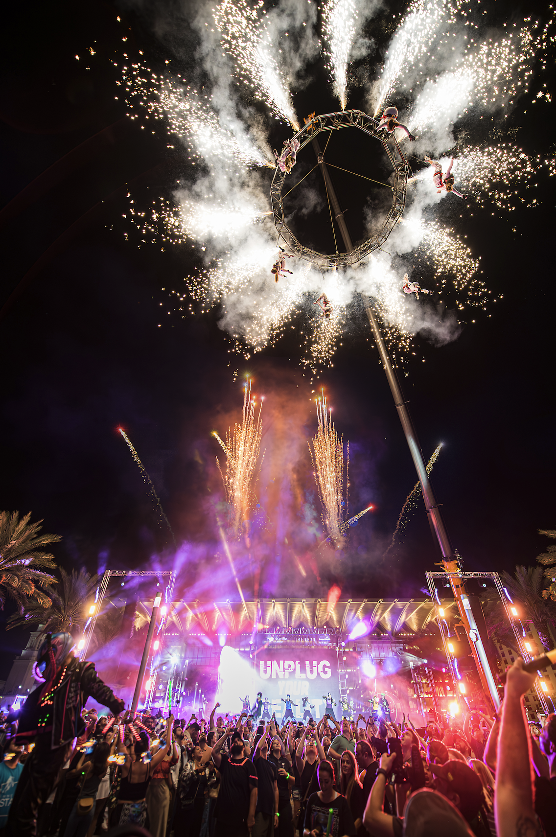 MESH acrobats hang from a crane of pyrotechnics