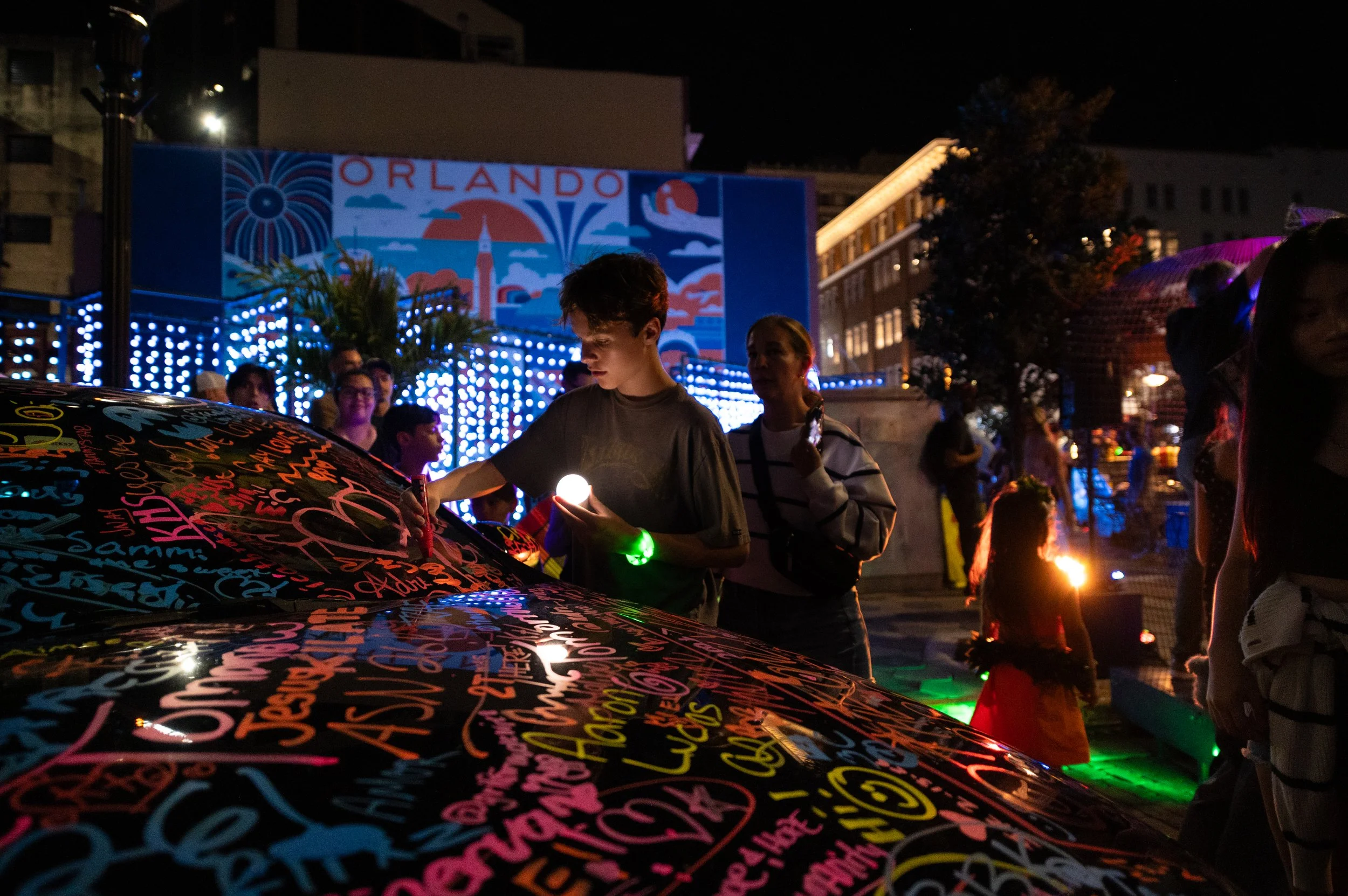 Guests paint on a car as part of the Brain Bros interactive art installation at IMMERSE