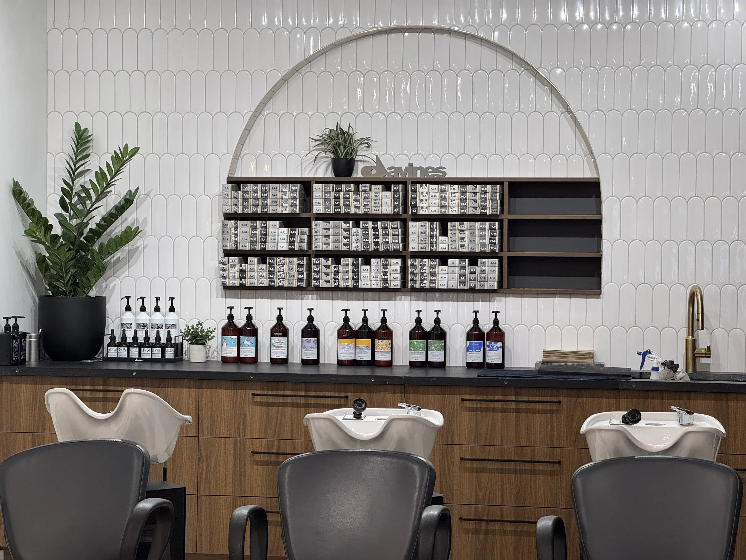 Butter Salon interior with Davines product bar, shampoo bowls, and precision cut consultation diagram