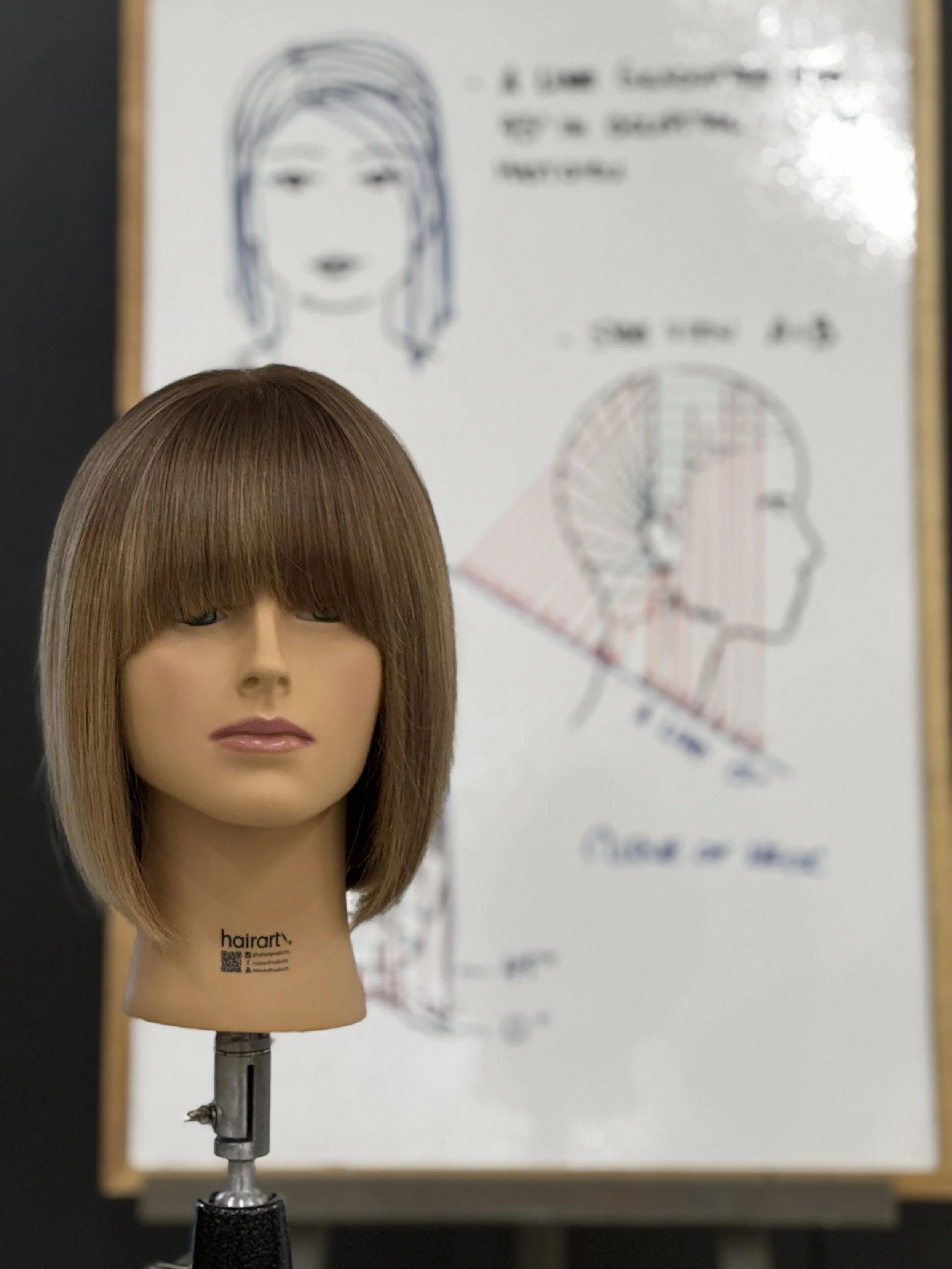 Hair training mannequin with precision bob cut and technical diagram at Butter Hair & Co. mentorship program