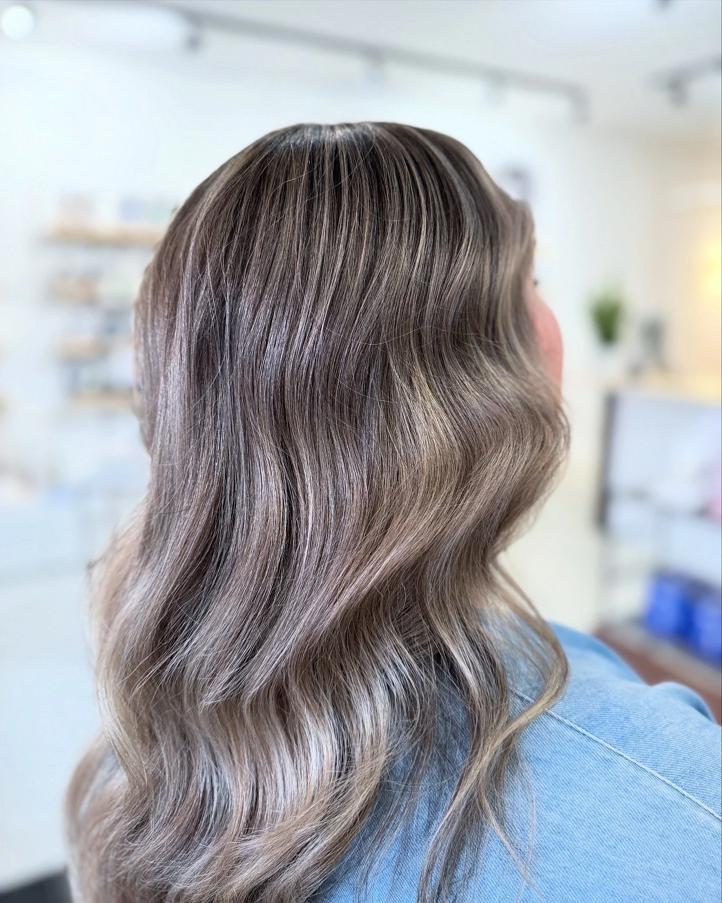 Woman showing lived-in balayage with soft blonde waves at Butter Salon Terrace, BC