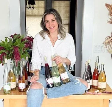 Photo of Kara Marie Groom winemaker with her wines