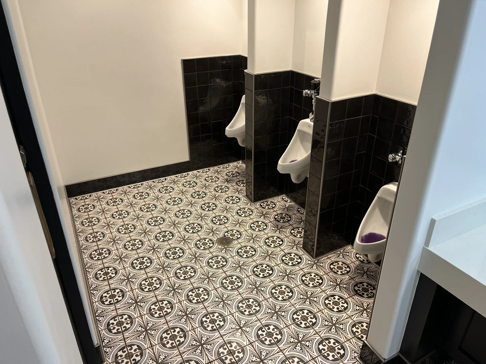 Concrete tile with black wall tile and Schluter trim