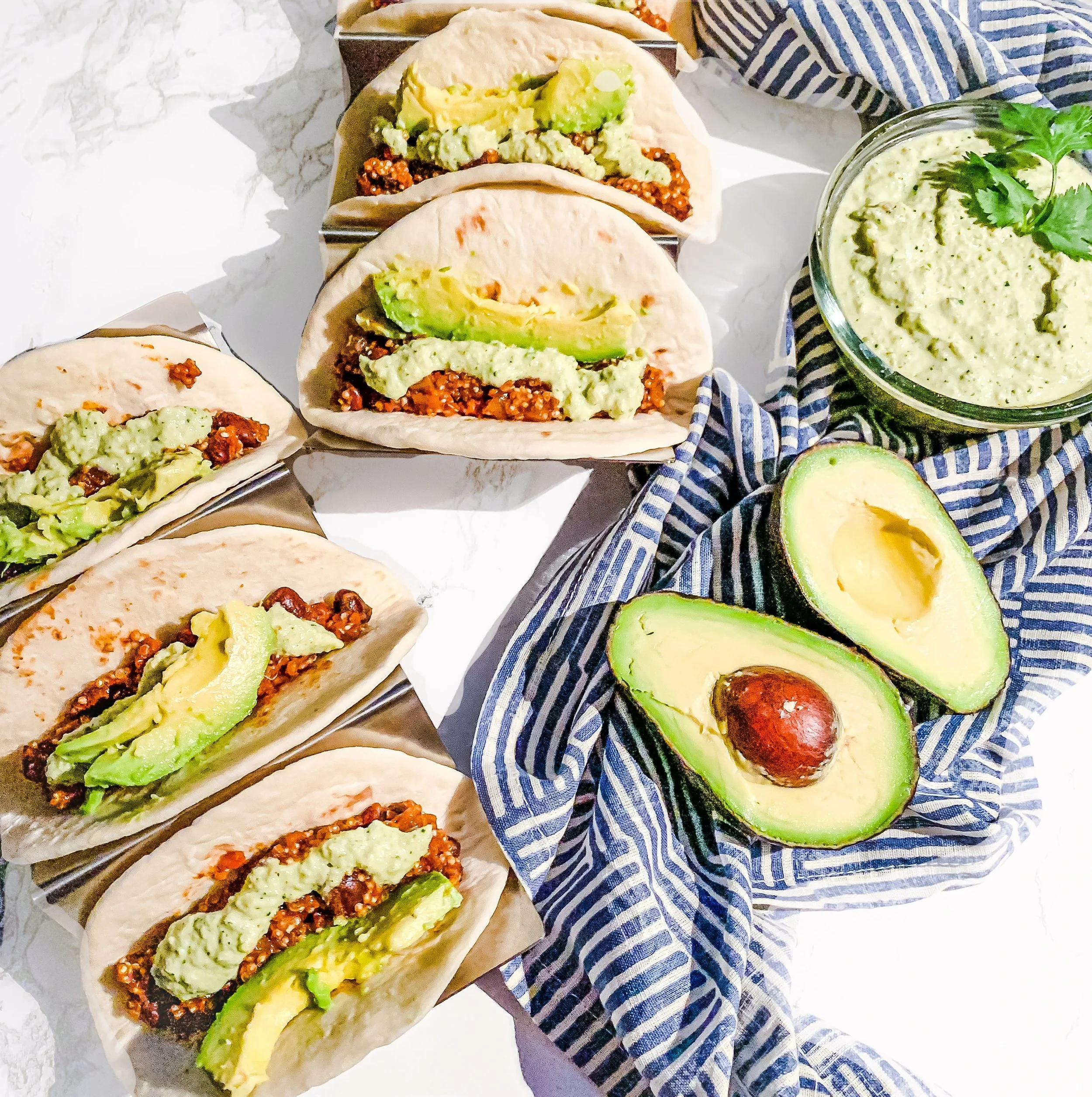 tacos with meat, avocado, and crema